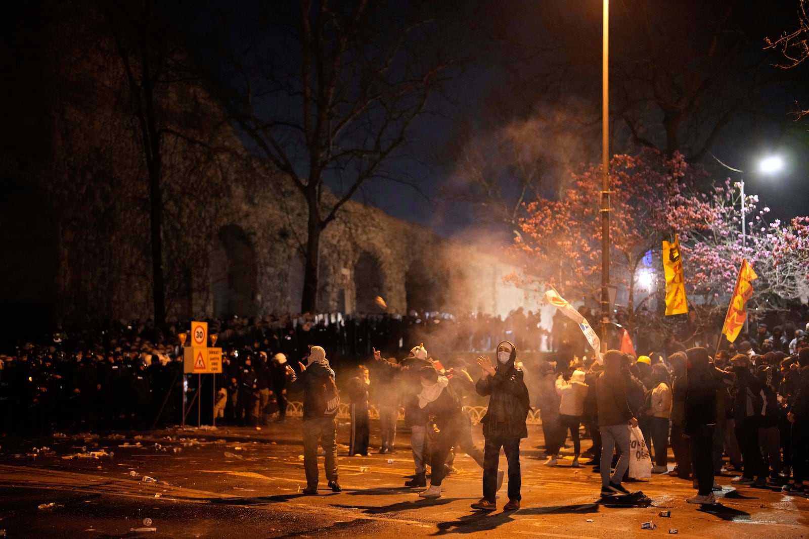 Protesters throw objects during clashes with anti riot police officers in a protest against the arrest of Istanbul's Mayor Ekrem Imamoglu in Istanbul, Turkey, Friday, March 21, 2025. (AP Photo/Emrah Gurel)