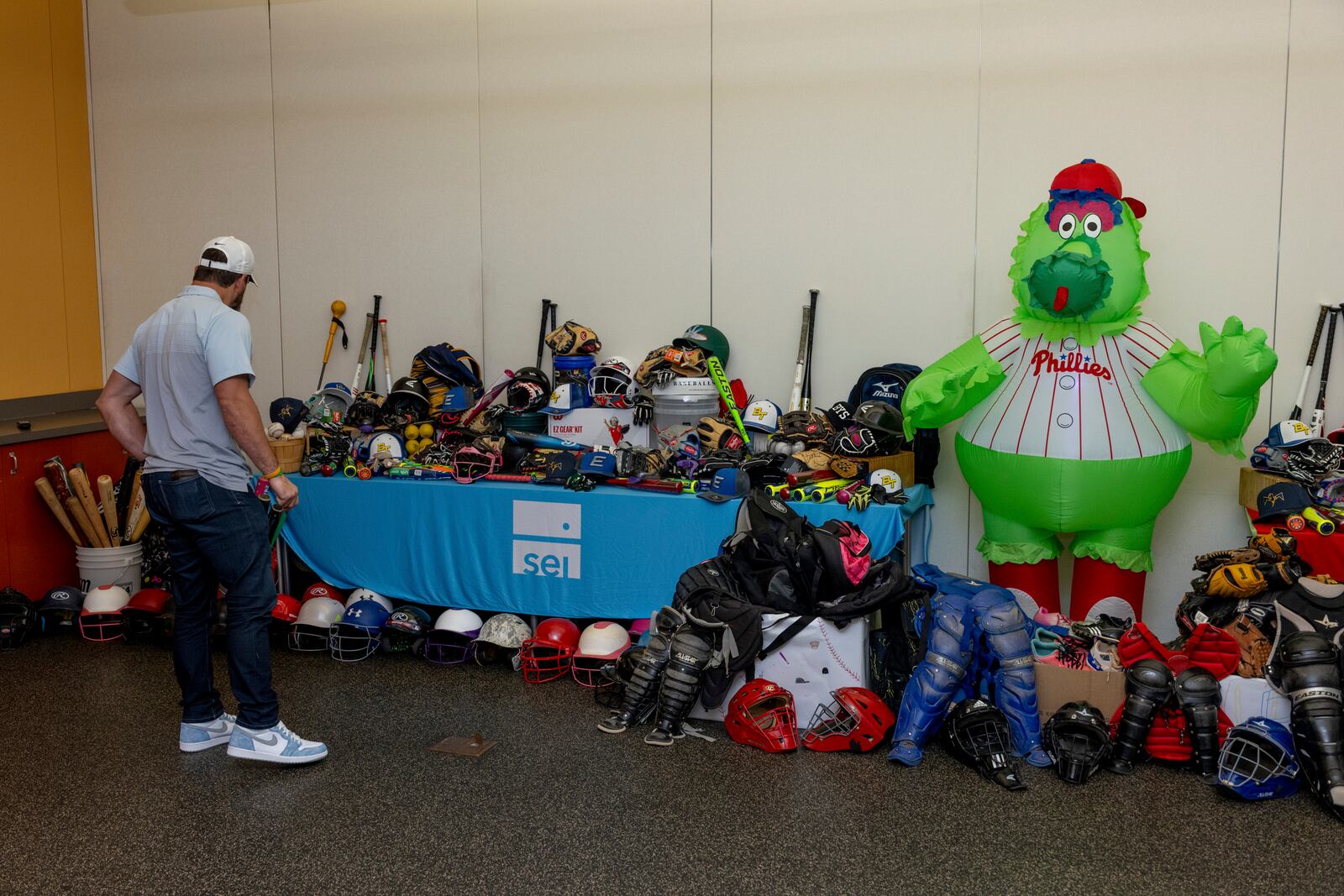 Kyle Schwarber, a 2011 Middletown High School graduate and designated hitter for the Philadelphia Phillies, looks over the 500 baseball and softball items donated to Middie Way Baseball from SEI. SUBMITTED PHOTO