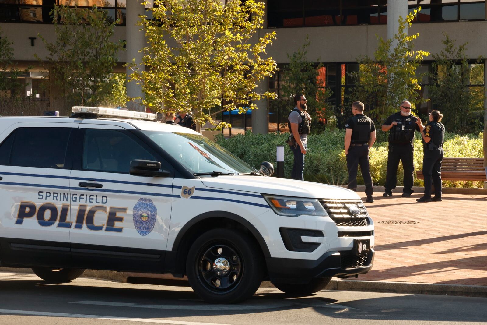 Springfield and Dayton police officers outside the City Hall building following an evacuation due to a threat Thursday. BILL LACKEY/STAFF