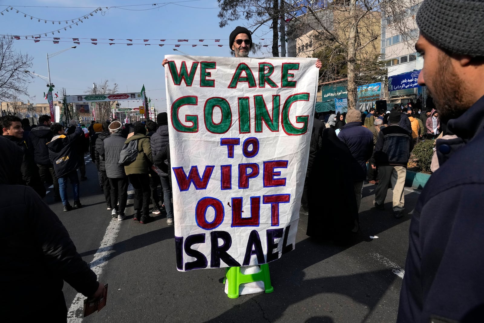 An Iranian demonstrator holds an anti-Israeli banner during a rally commemorating anniversary of 1979 Islamic Revolution that toppled the late pro-U.S. Shah Mohammad Reza Pahlavi and brought Islamic clerics to power, in Tehran, Iran, Monday, Feb. 10, 2025. (AP Photo/Vahid Salemi)