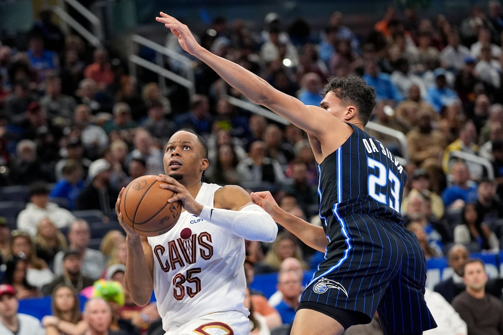 Cleveland Cavaliers forward Isaac Okoro (35) lines up a shot against Orlando Magic forward Tristan da Silva (23) during the second half of an NBA basketball game, Tuesday, Feb. 25, 2025, in Orlando, Fla. (AP Photo/John Raoux)