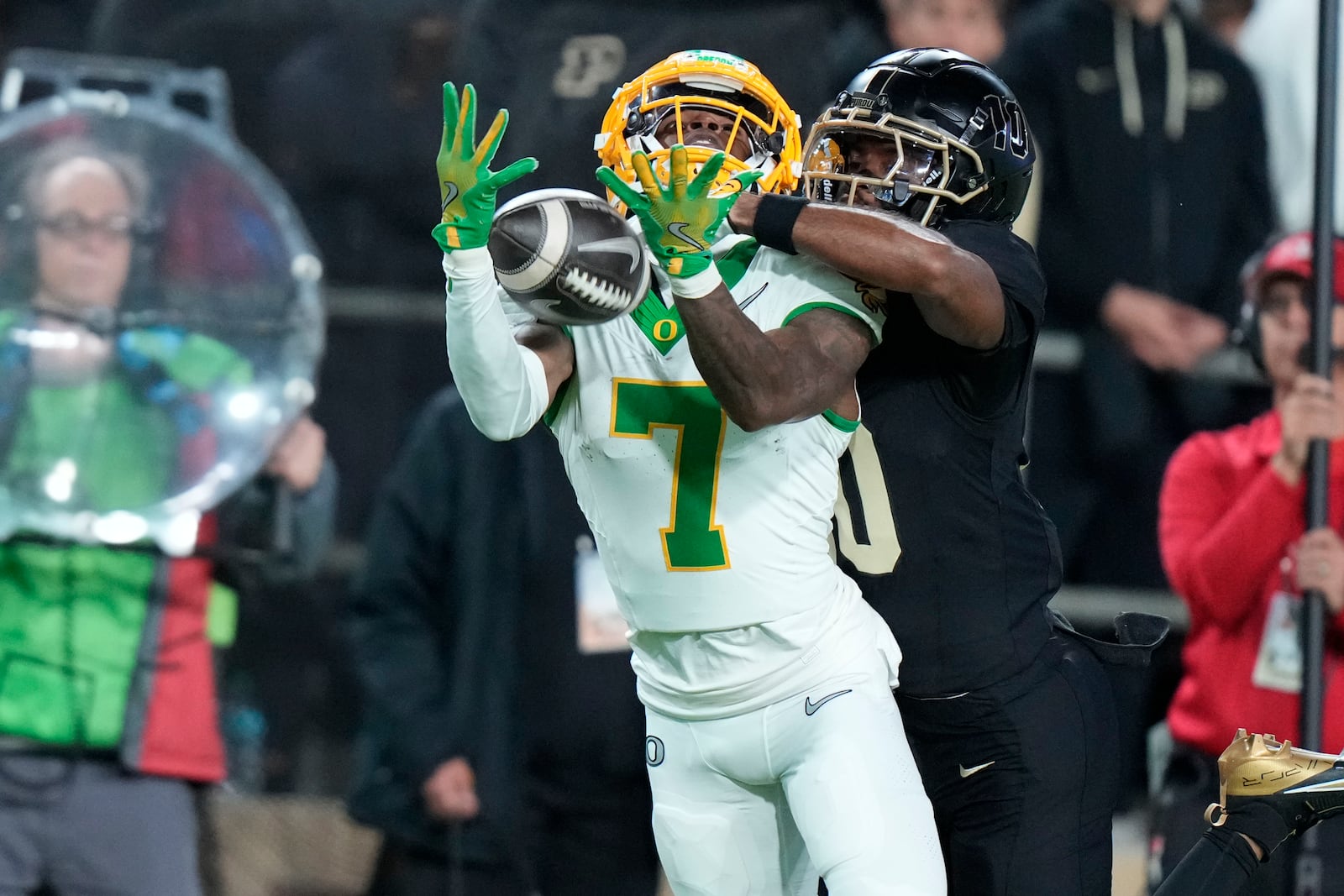 Oregon wide receiver Evan Stewart (7) pulls in a pass under the defense of Purdue defensive back Kyndrich Breedlove, center right, during the first half of an NCAA college football game in West Lafayette, Ind., Friday, Oct. 18, 2024. (AP Photo/AJ Mast)