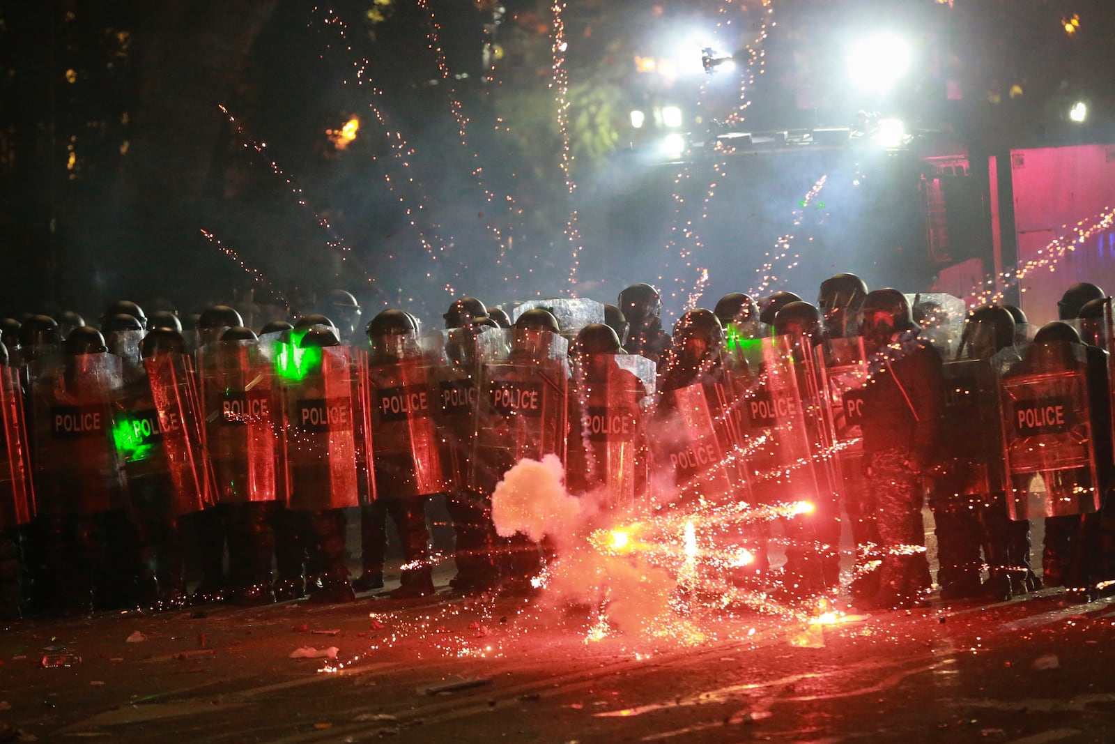 Demonstrators use firecrackers against police as police block a street to prevent protesters rallying against the government's decision to suspend negotiations on joining the European Union for four years, outside the parliament's building in Tbilisi, Georgia, early Sunday, Dec. 1, 2024. (AP Photo/Zurab Tsertsvadze)