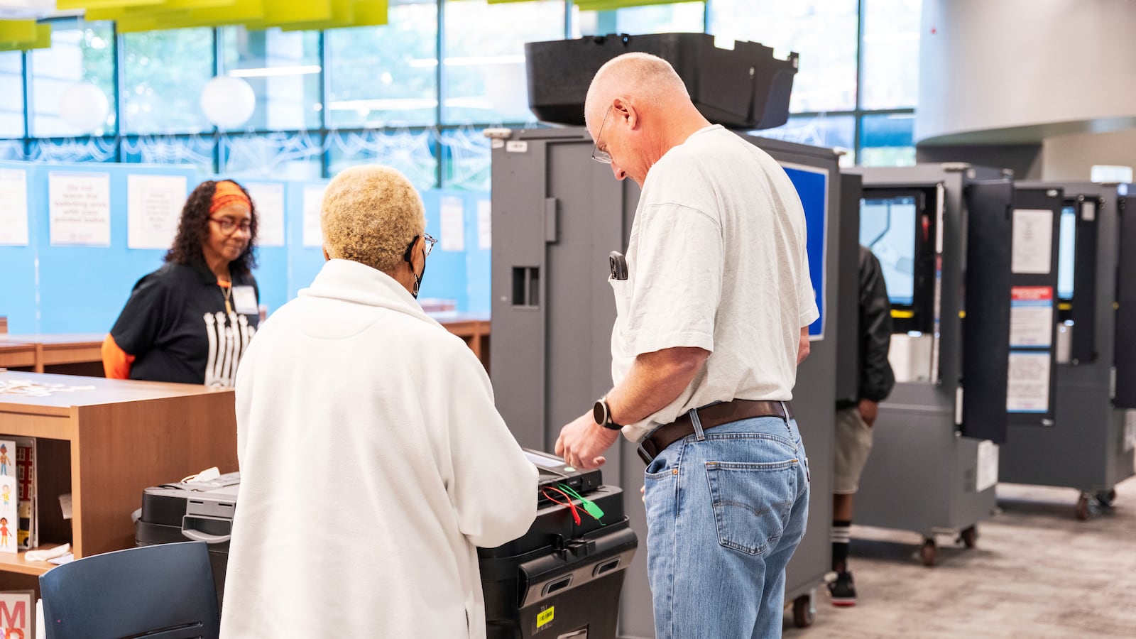 A man receives receives instructions from a volunteer on how to properly discard his ballot receipt at the polling station, Thursday, Oct. 31, 2024, in Atlanta. (AP Photo/Jason Allen)