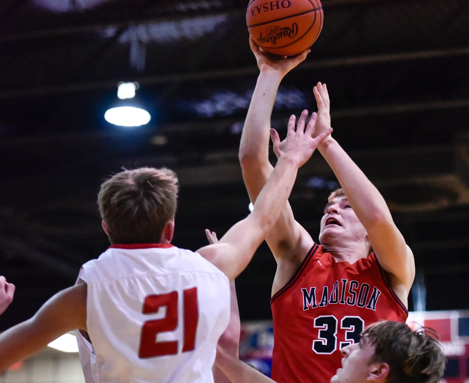 Madison’s Levi McMonigle puts up a shot over Carlisle’s Nolan Burney during Friday night’s game at Carlisle. Visiting Madison won 58-39. NICK GRAHAM/STAFF