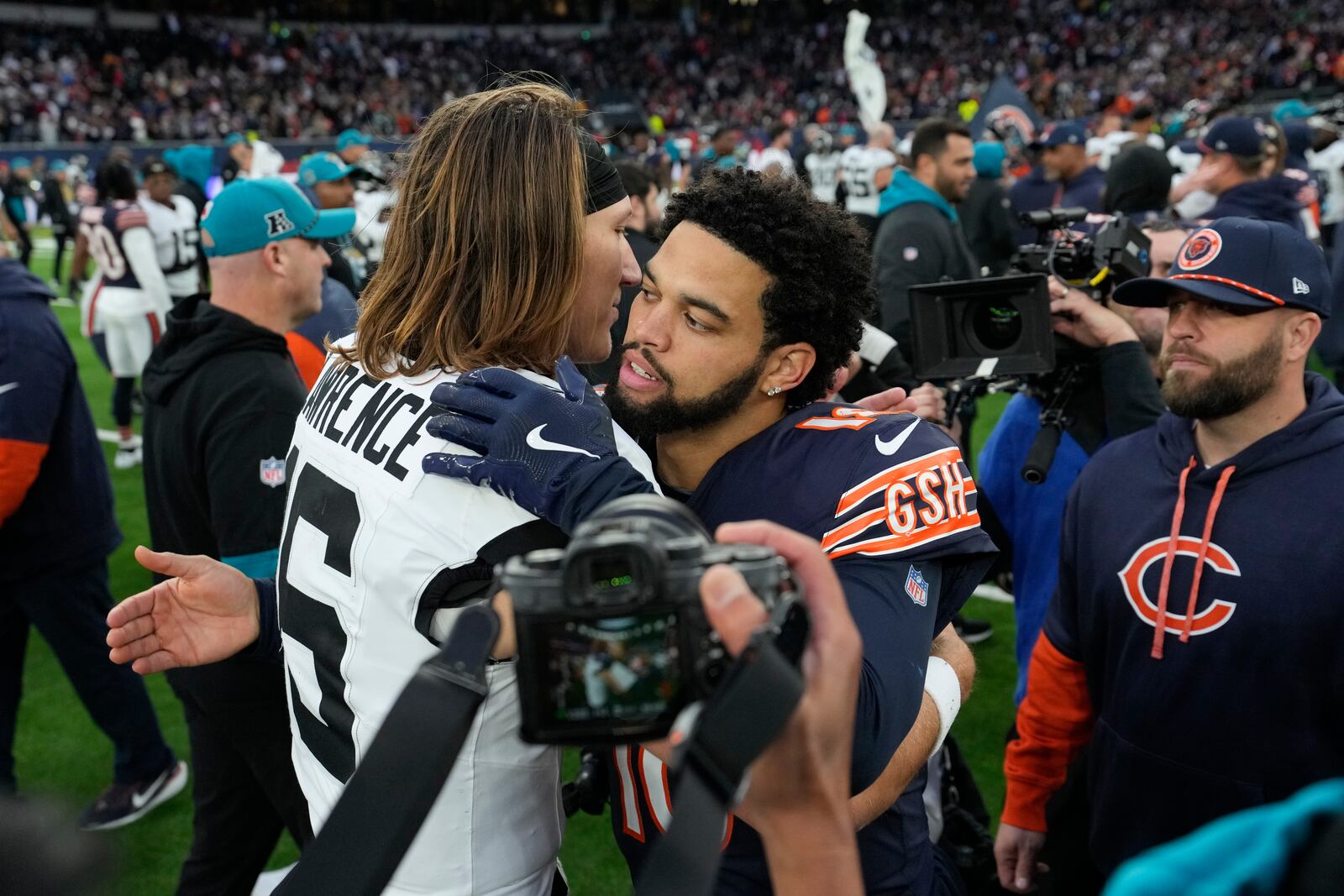 Chicago Bears quarterback Caleb Williams (18), right, greets Jacksonville Jaguars quarterback Trevor Lawrence (16) after an NFL football game at the Tottenham Hotspur stadium between the Jacksonville Jaguars and Chicago Bears in London, Sunday, Oct. 13, 2024. (AP Photo/Steve Luciano)