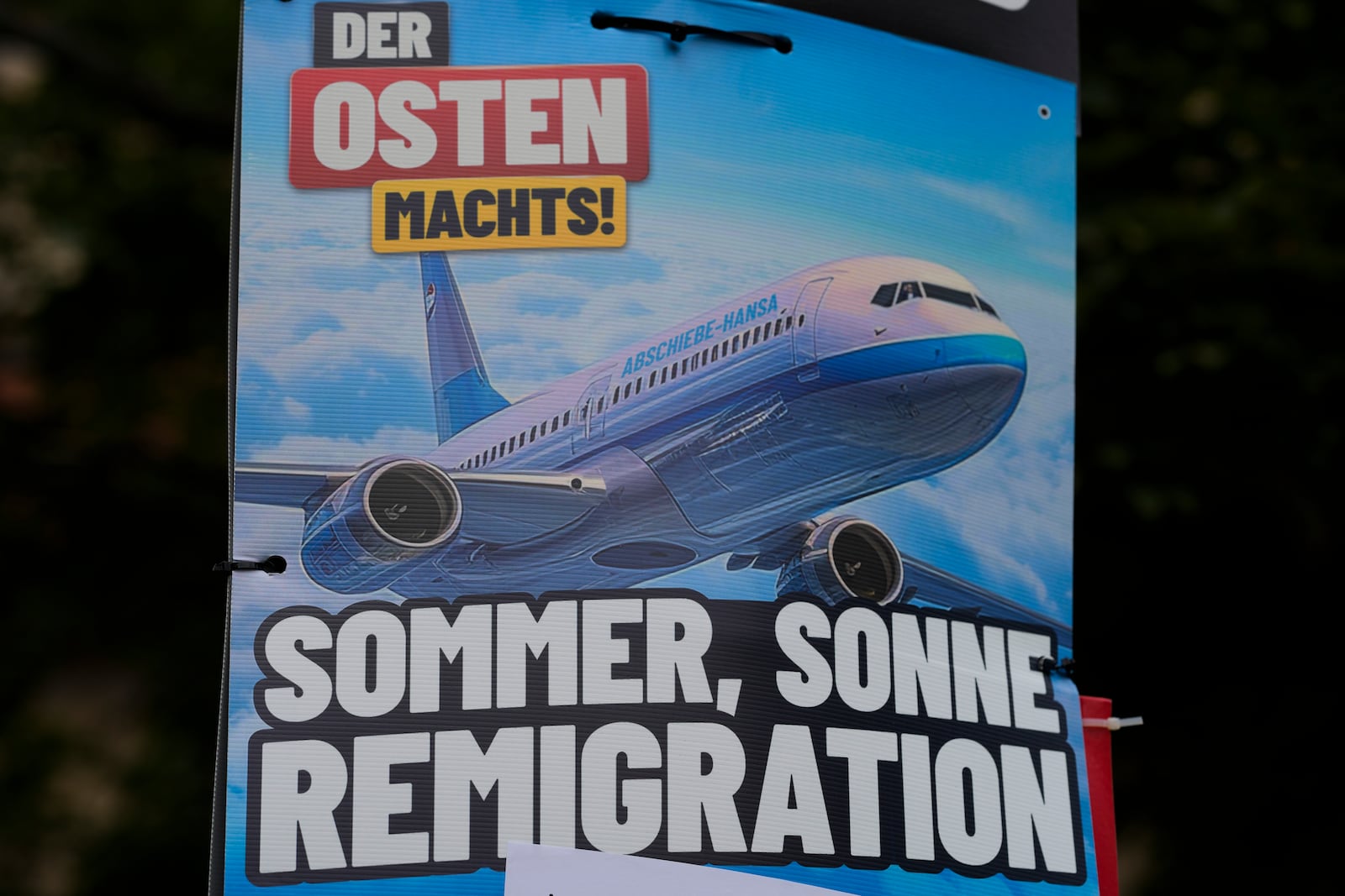 FILE - An AfD election campaign posters showing the slogan "summer, sun, remigration," and the photo of a plane dubbed "deportation airline" is displayed in Erfurt, Germany, Wednesday, Aug. 14, 2024. (AP Photo/Markus Schreiber, File)