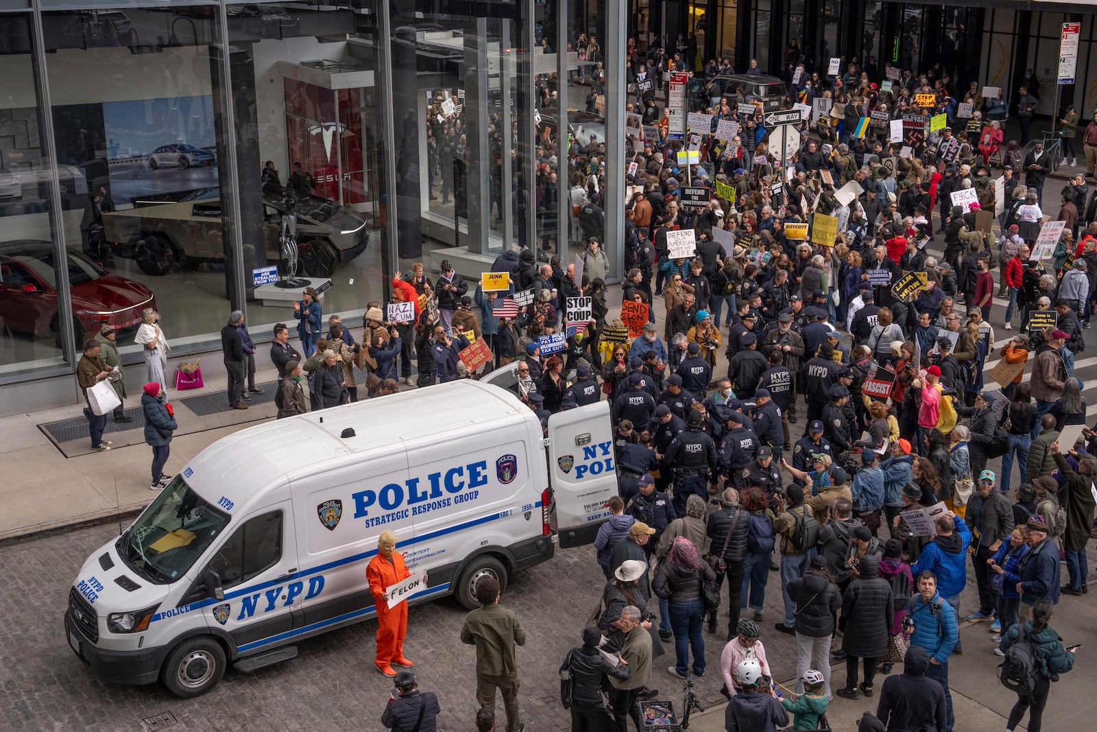 Demonstrators are arrested by NYPD officers during a protest against Elon Musk and Tesla outside of a Tesla showroom, Saturday, March 01, 2025 in New York. (AP Photo/Adam Gray)