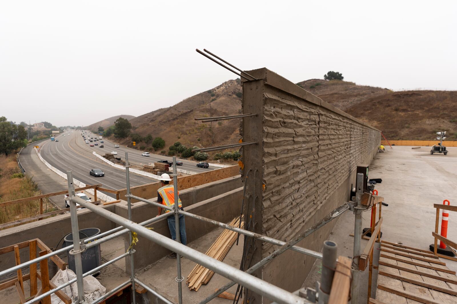 FILE - A construction worker looks over the 101 Freeway from the Wallis Annenberg Wildlife Crossing in Agoura Hills, Calif., Oct. 15, 2024. (AP Photo/Jae C. Hong, File)