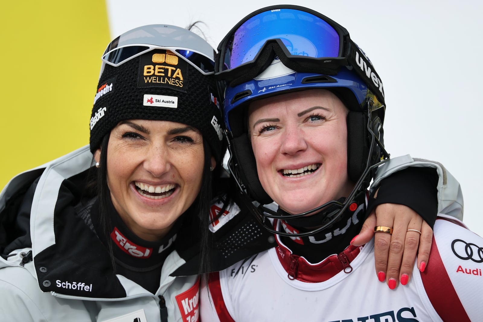 Austria's Stephanie Venier, left, hugs teammates Austria's Katharina Truppe at the finish area of a slalom run of a women's team combined event, at the Alpine Ski World Championships, in Saalbach-Hinterglemm, Austria, Tuesday, Feb. 11, 2025. (AP Photo/Marco Trovati)