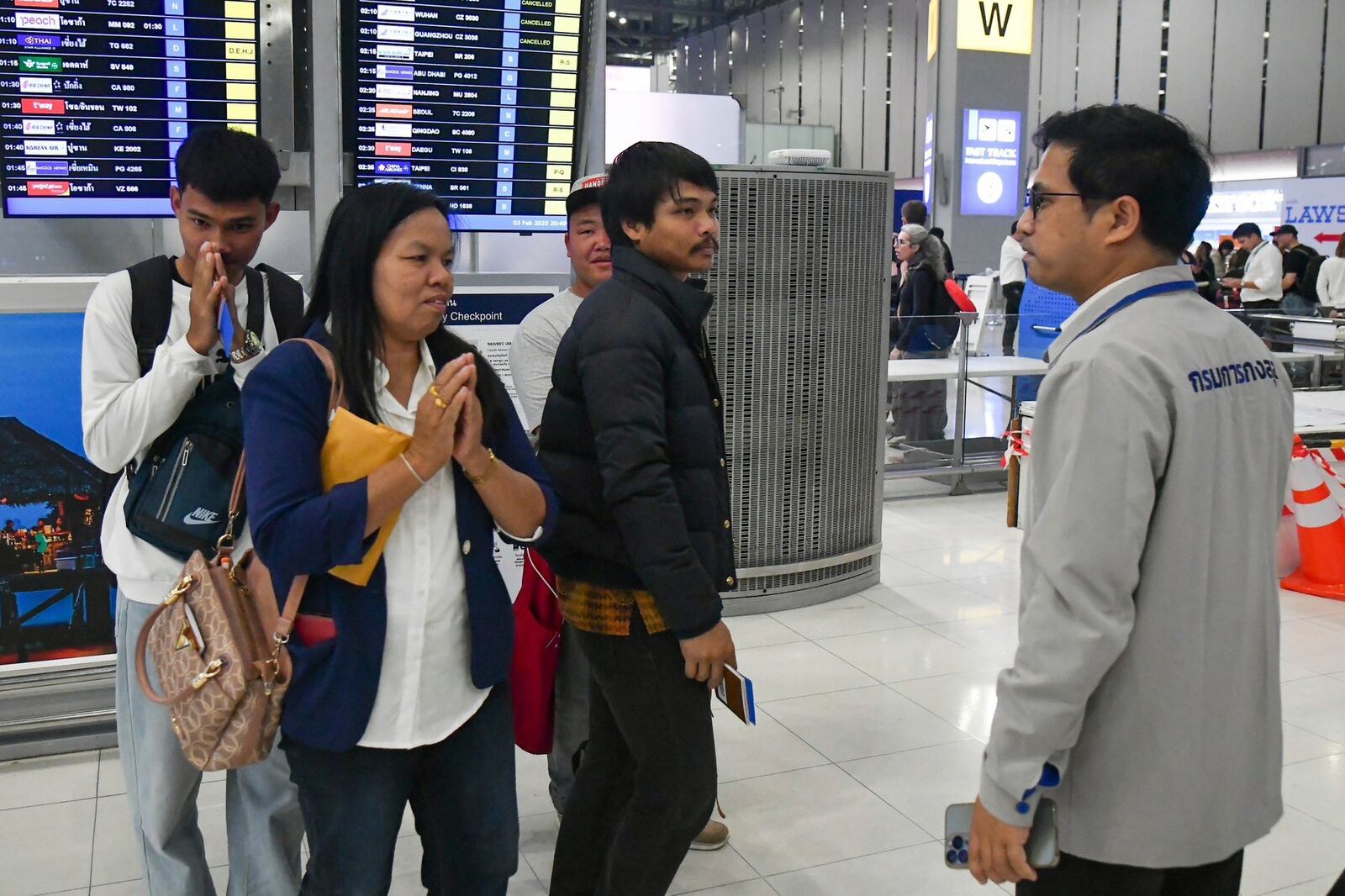 In this photo provided by the Thai Foreign Ministry, an official, right, from the Department of Consular Affairs, talks to family members of released Thai hostages freed from Hamas, before they travel to Tel Aviv, Israel, from the Suvarnabhumi International Airport in Samut Prakarn Province, Thailand, Monday, Feb. 3, 2025. (Thai Foreign Ministry via AP)