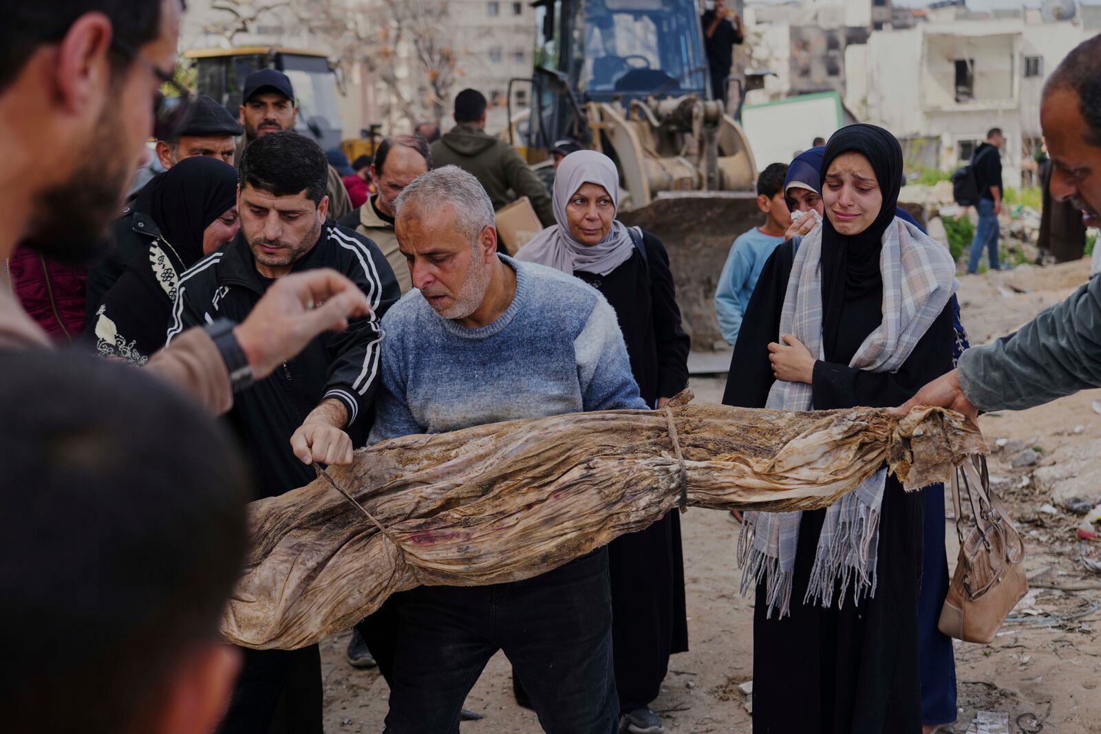 The bodies of Palestinians killed during the Israel-Hamas war and were buried in a mass grave at Shifa Hospital yard are exhumed for identification and reburial in Gaza City's official cemeteries, on Thursday, March 13, 2025. (AP Photo/Abdel Kareem Hana)