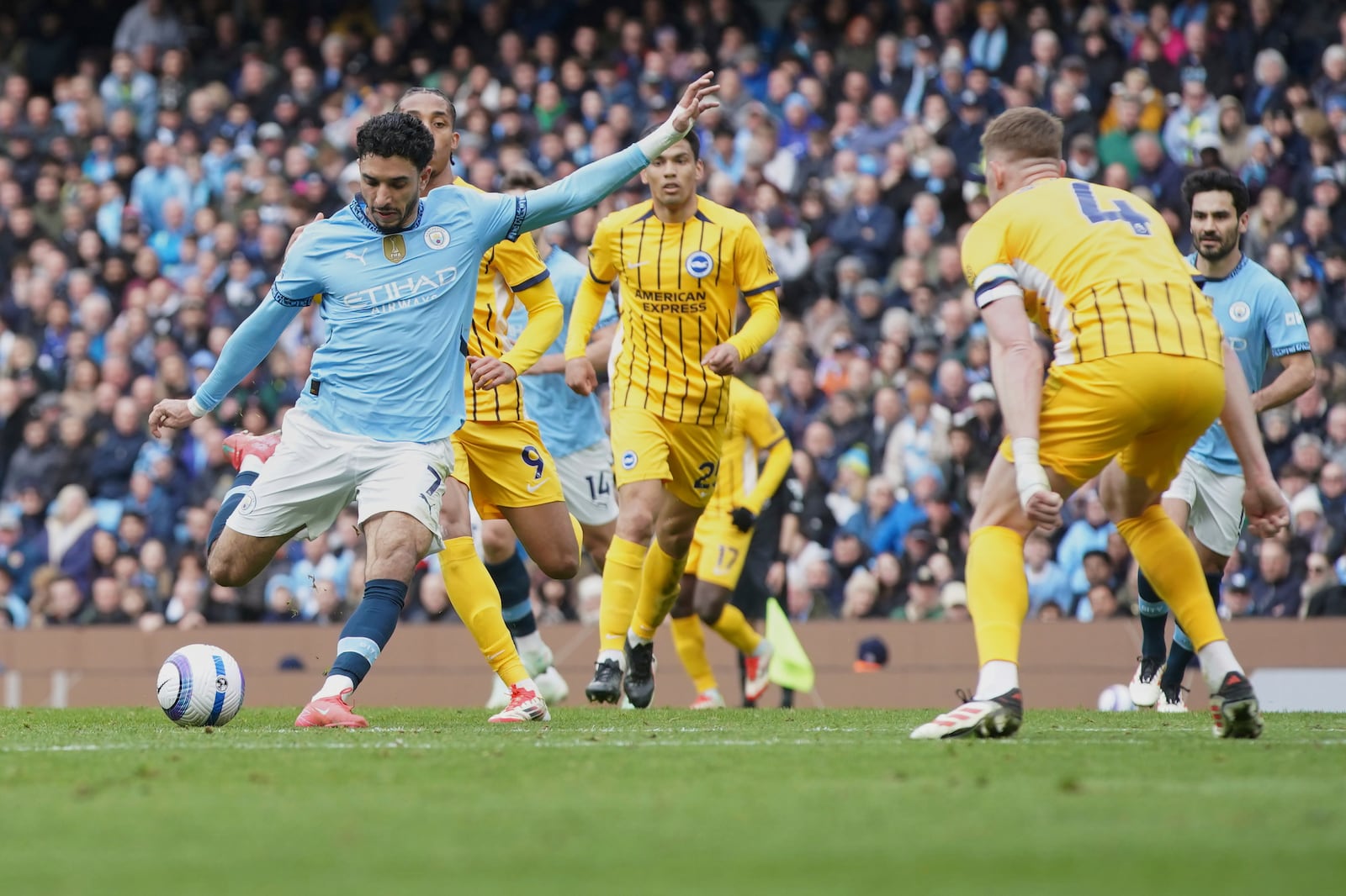 Manchester City's Omar Marmoush, left, attempts a shot at goal in front of Brighton's Adam Webster to scores his side's second goal during the English Premier League soccer match between Manchester City and Brighton and Hove Albion at Etihad stadium in Manchester, England, Saturday, March 15, 2025. (AP Photo/Ian Hodgson)