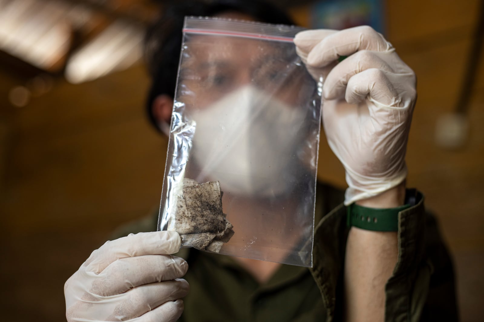 Dhany Alfalah, a researcher with Satya Bumi, a nonprofit environmental organization, shows dust samples collected from a house on Kabaena Island in South Sulawesi, Indonesia, Friday, Nov. 15, 2024. (AP Photo/Yusuf Wahil)