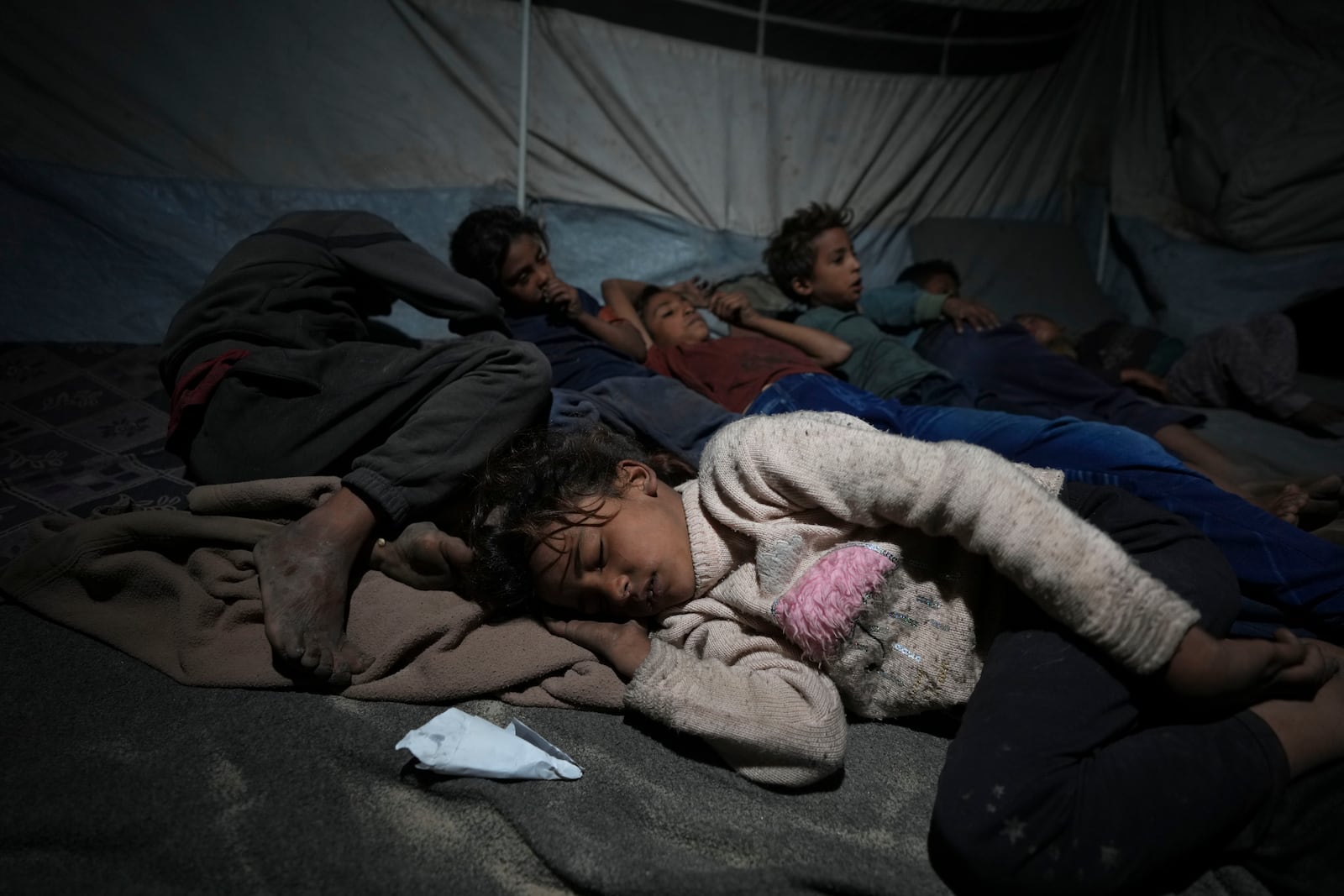 Shireen Daifallah's children, who were displaced from northern Gaza, sleep in their tent at a camp for displaced people in Deir al-Balah. Gaza Strip, Saturday, Nov. 30, 2024. (AP Photo/Abdel Kareem Hana)