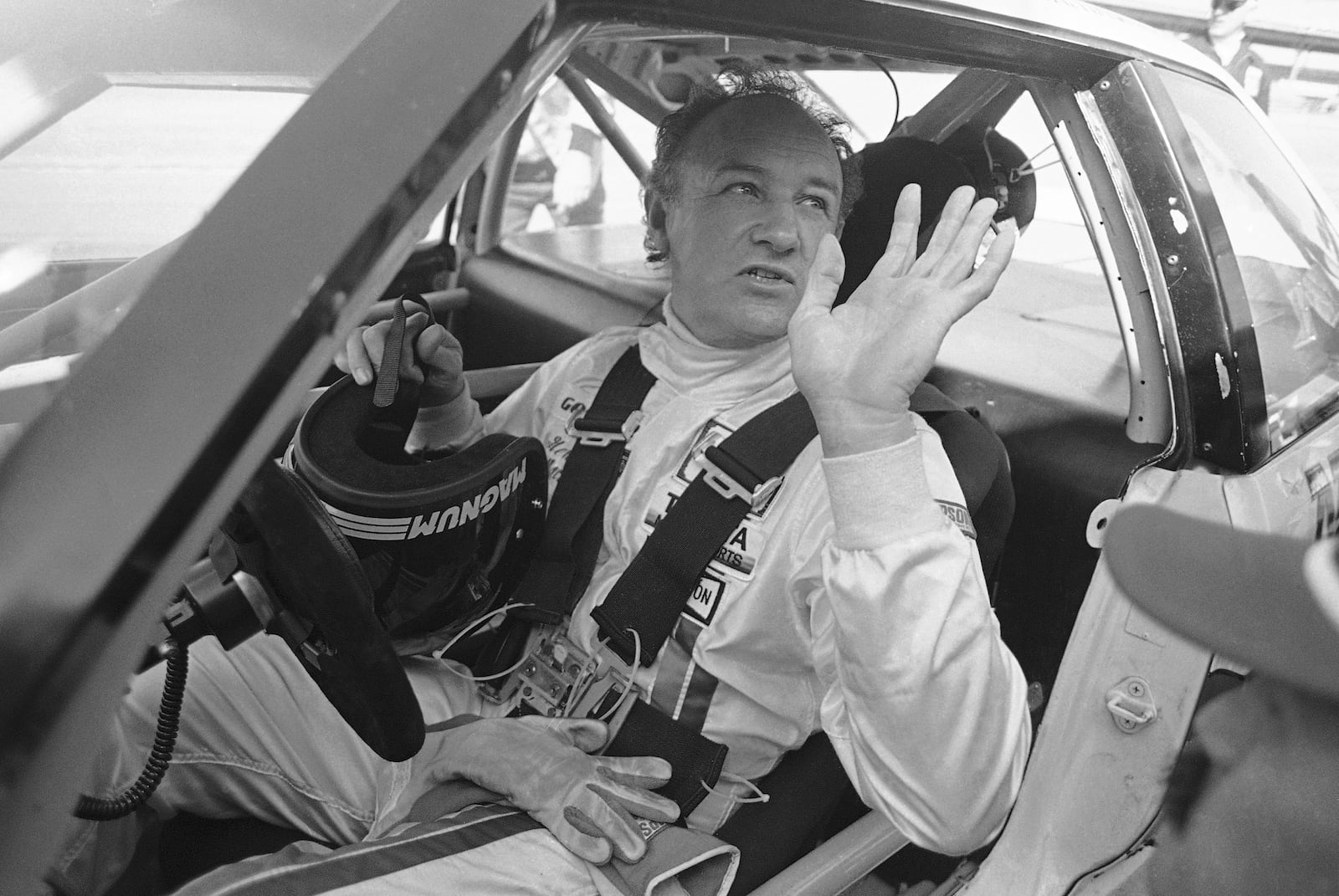 FILE - Actor Gene Hackman waves as he starts out for a practice run in his Toyota Celica, Feb. 5, 1983 at the Daytona International Speedway in preparation for the Daytona 24 Hour Endurac Race. This race marks the start of Hickman?s career as a professional driver. (AP Photo/Bob Self, File)