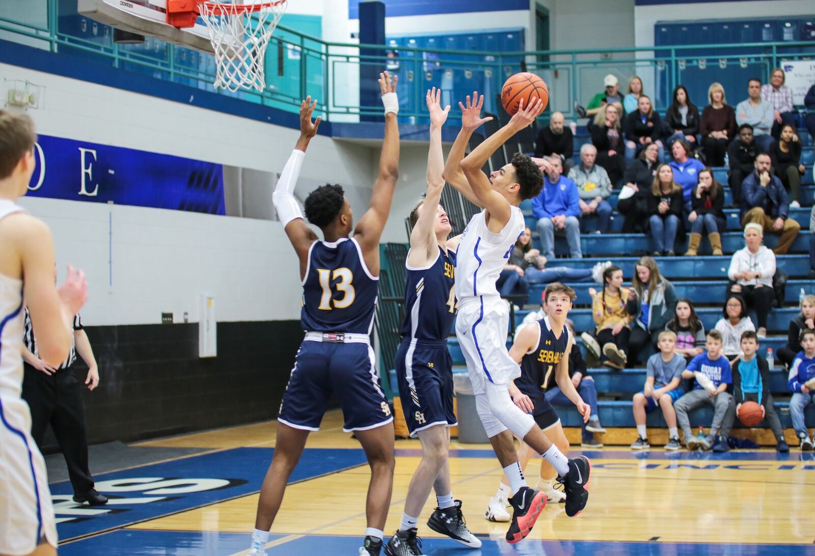 Cincinnati Christian’s Jalon Percy (21) shoots over Curtis Harrison (13) and Andrew Brown (44) of Seven Hills during Friday night’s game at CCS. Seven Hills won 45-40. PHOTO BY KRAE/WWW.KRAEPHOTOGRAPHY.COM