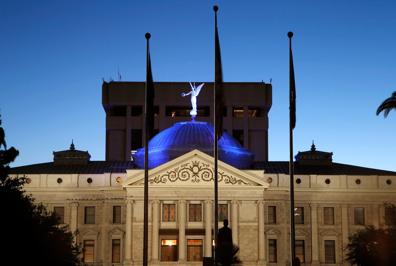 FILE - The dome of the Arizona Capitol building is illuminated in blue as buildings and structures around the state are lit in blue as a symbol of support for Arizona's frontline medical workers and emergency responders battling the coronavirus Wednesday, April 15, 2020, in Phoenix. (AP Photo/Ross D. Franklin, File)