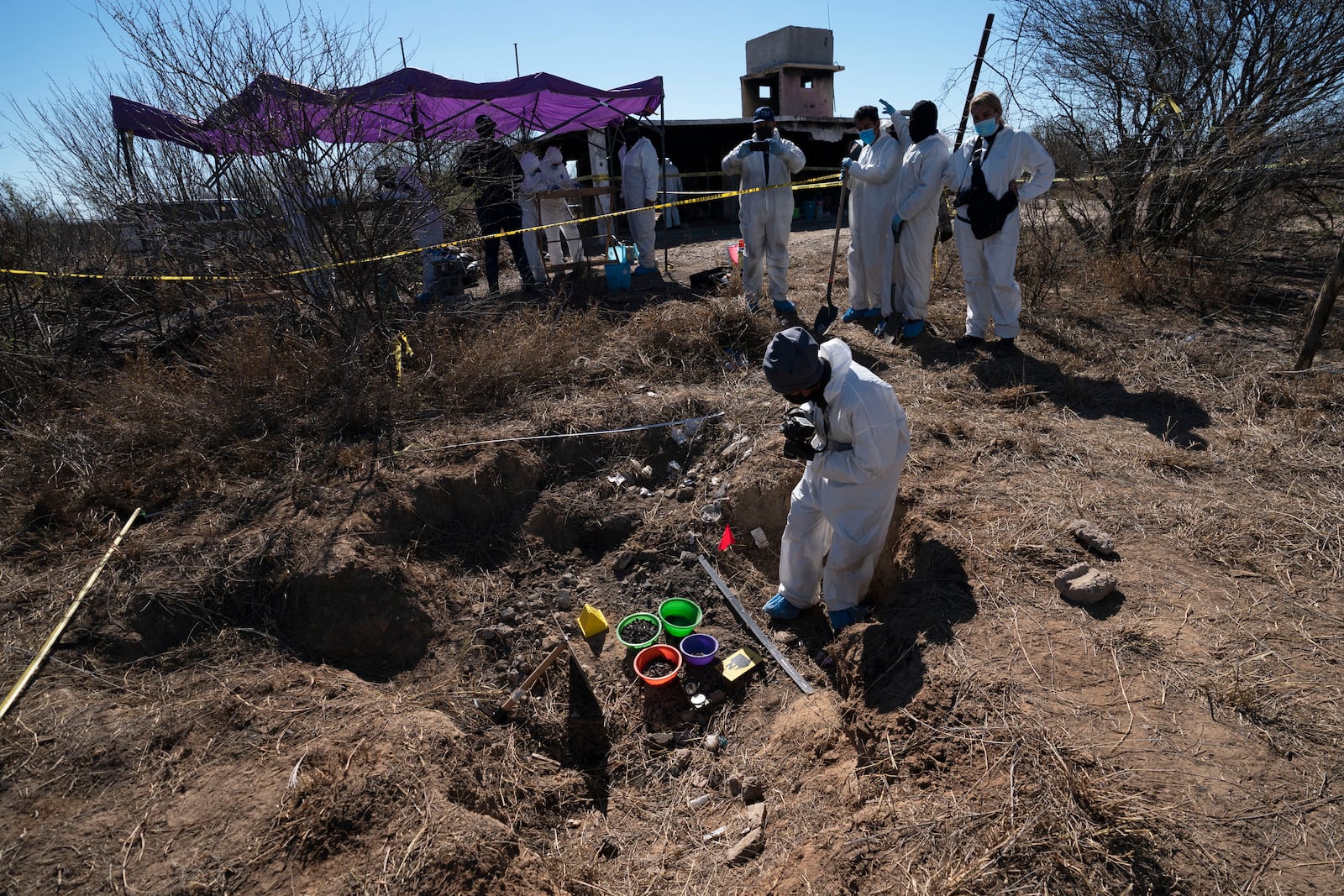 FILE - Forensic technicians excavate a field on a plot of land referred to as a cartel "extermination site" where burned human remains are buried, on the outskirts of Nuevo Laredo, Mexico, Feb. 8, 2022. (AP Photo/Marco Ugarte, File)