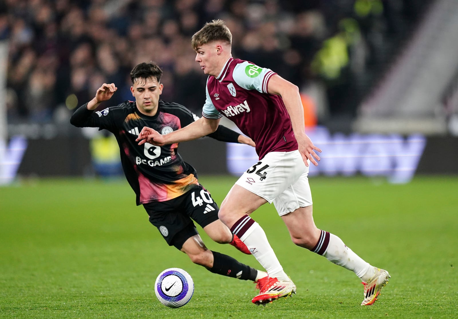 West Ham United's Evan Ferguson, right, and Leicester City's Facundo Buonanotte in action during the English Premier League soccer match between West Ham United and Leicester City at the London Stadium, London, Thursday Feb. 27, 2025. (Zac Goodwin/PA via AP)