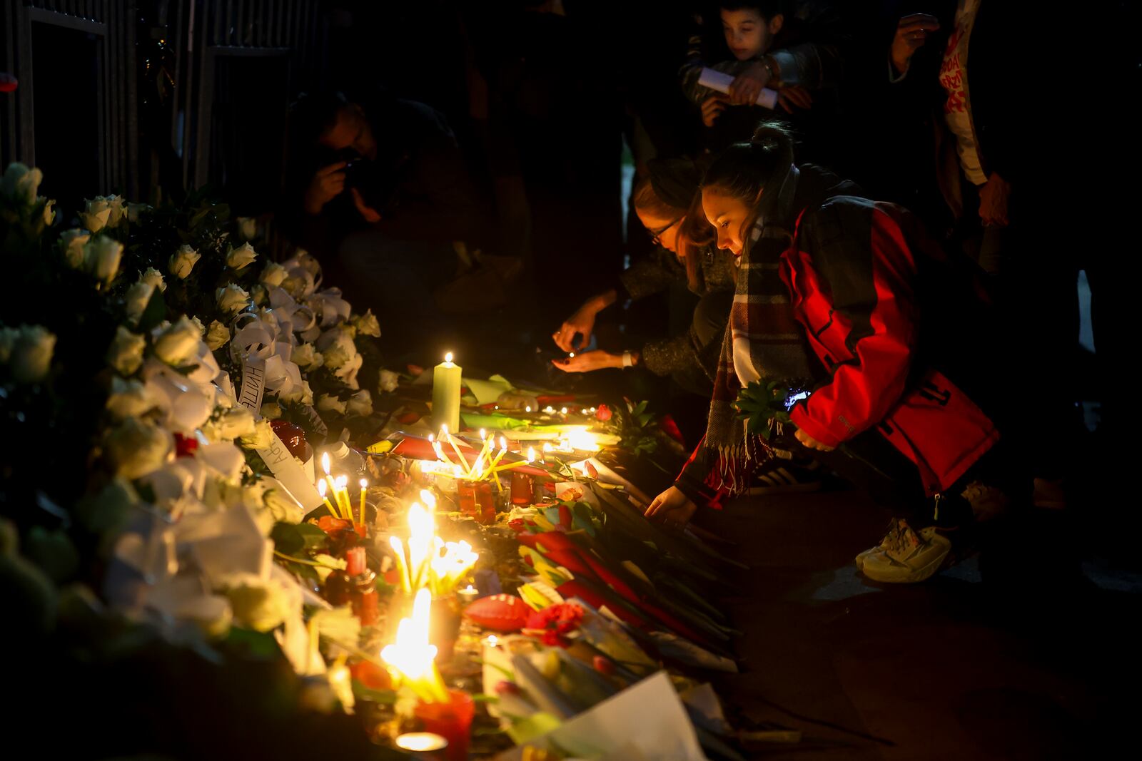 People lay flowers during a protest over the collapse of a concrete canopy that killed 15 people more than two months ago, in Novi Sad, Serbia, Friday, Jan. 31, 2025. (AP Photo/Armin Durgut)