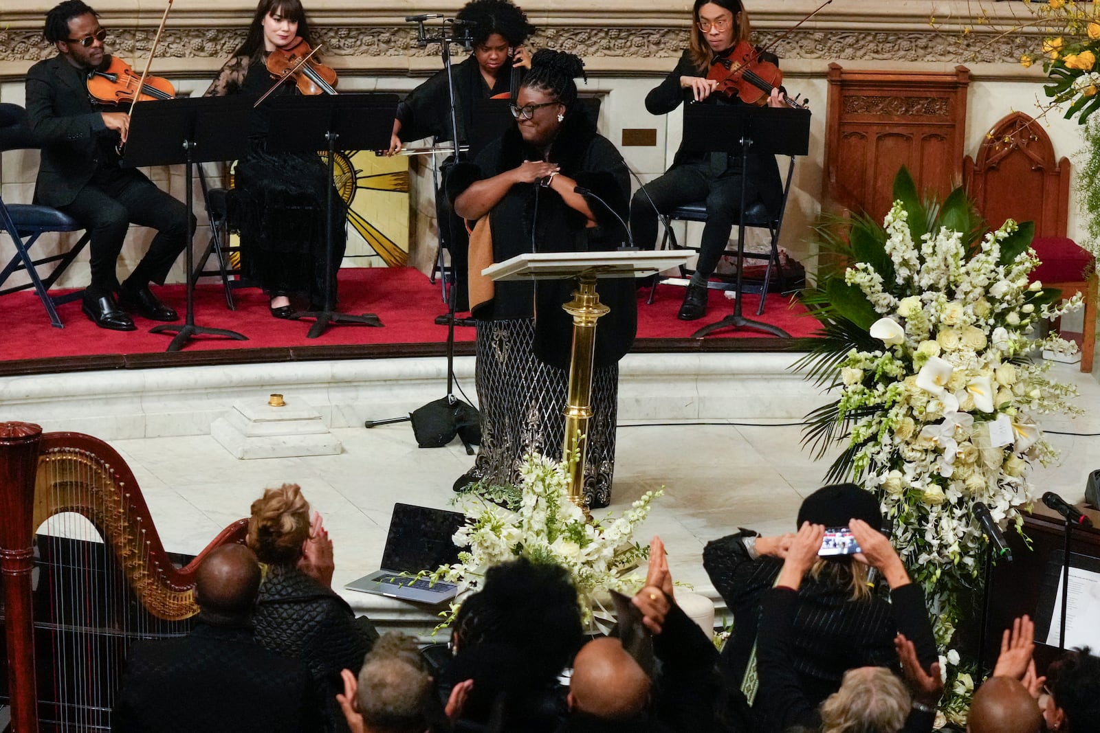 Nia Drummond, front, and The Nebulous String Quartet from Berklee College of Music perform during a ceremony in celebration of Roberta Flack's life at The Abyssinian Baptist Church on Monday, March 10, 2025, in New York. (AP Photo/Richard Drew)