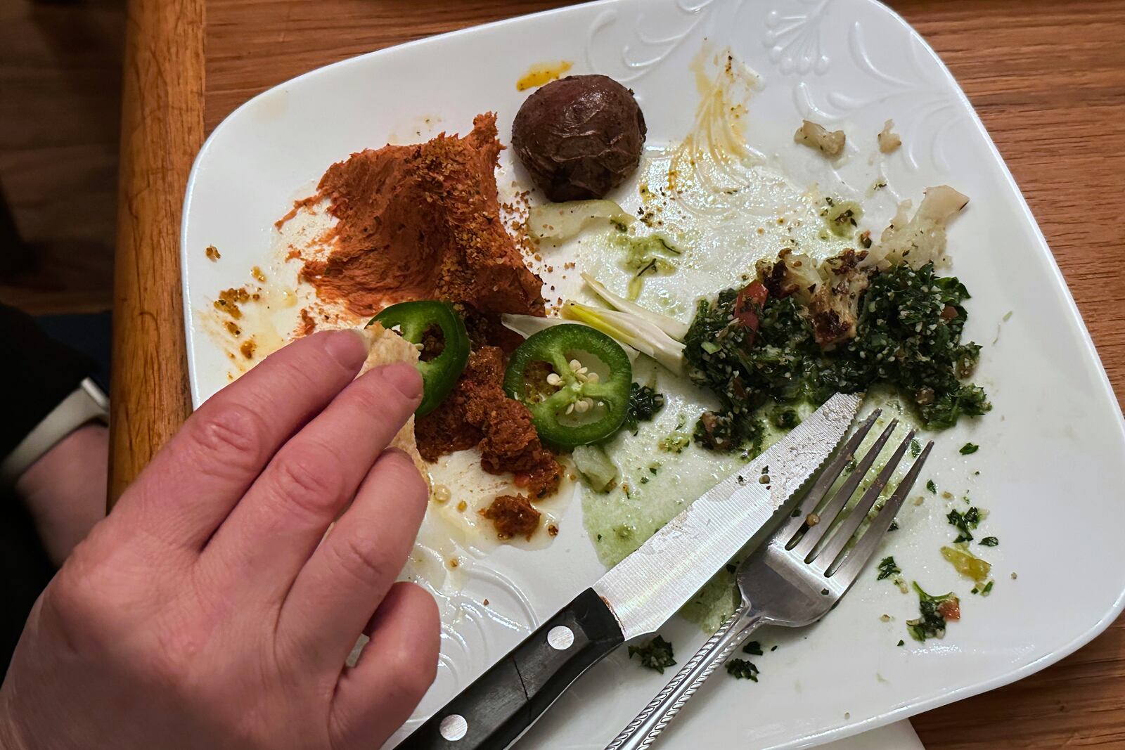 A diner eats from a plate of food during an iftar dinner Friday, March 7, 2025, in Dearborn, Mich. (AP Photo/Mike Householder)