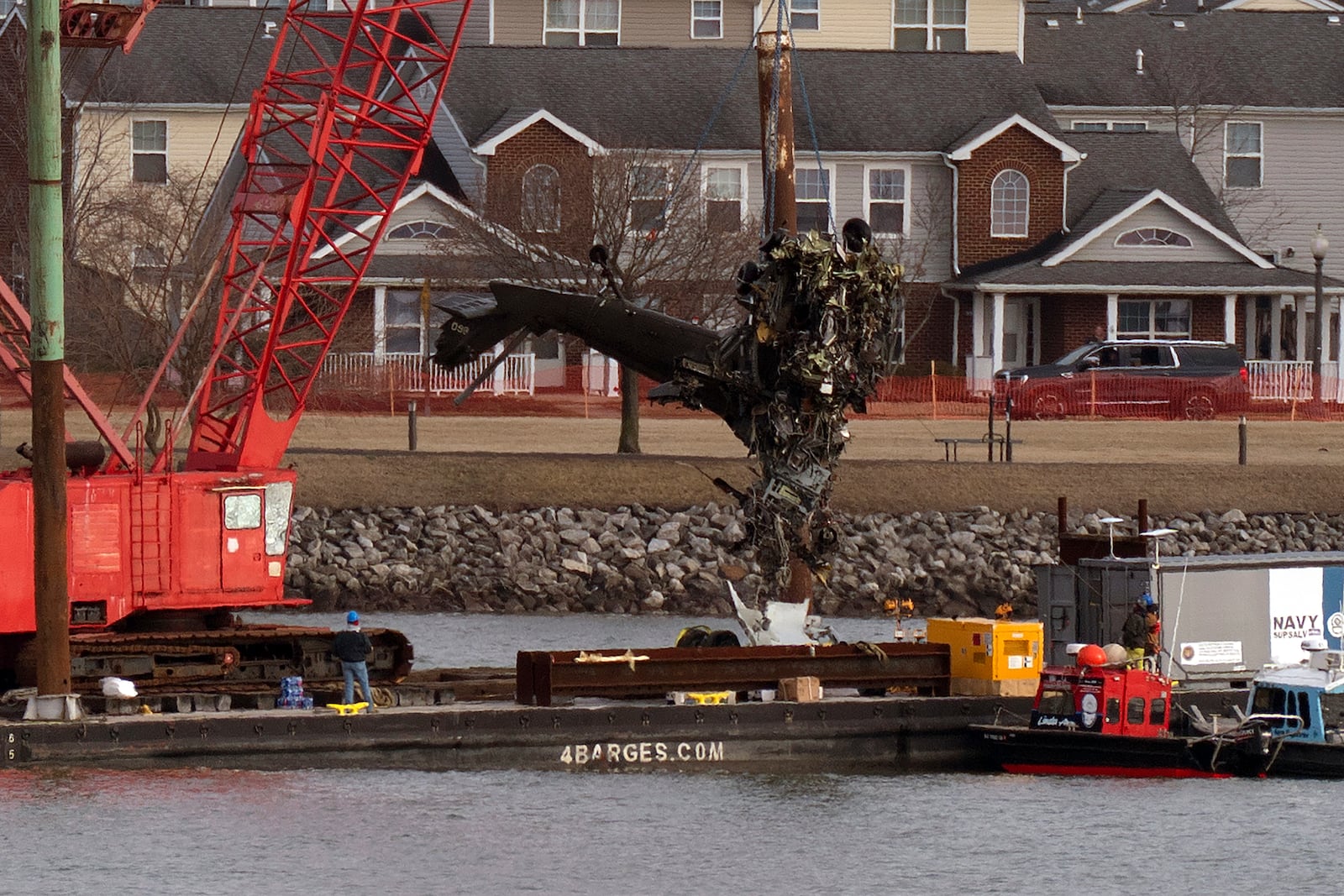 Rescue and salvage crews pull up a part of a Army Black Hawk helicopter that collided midair with an American Airlines jet, at a wreckage site in the Potomac River from Ronald Reagan Washington National Airport, Thursday, Feb. 6, 2025, in Arlington, Va. (AP Photo/Jose Luis Magana)