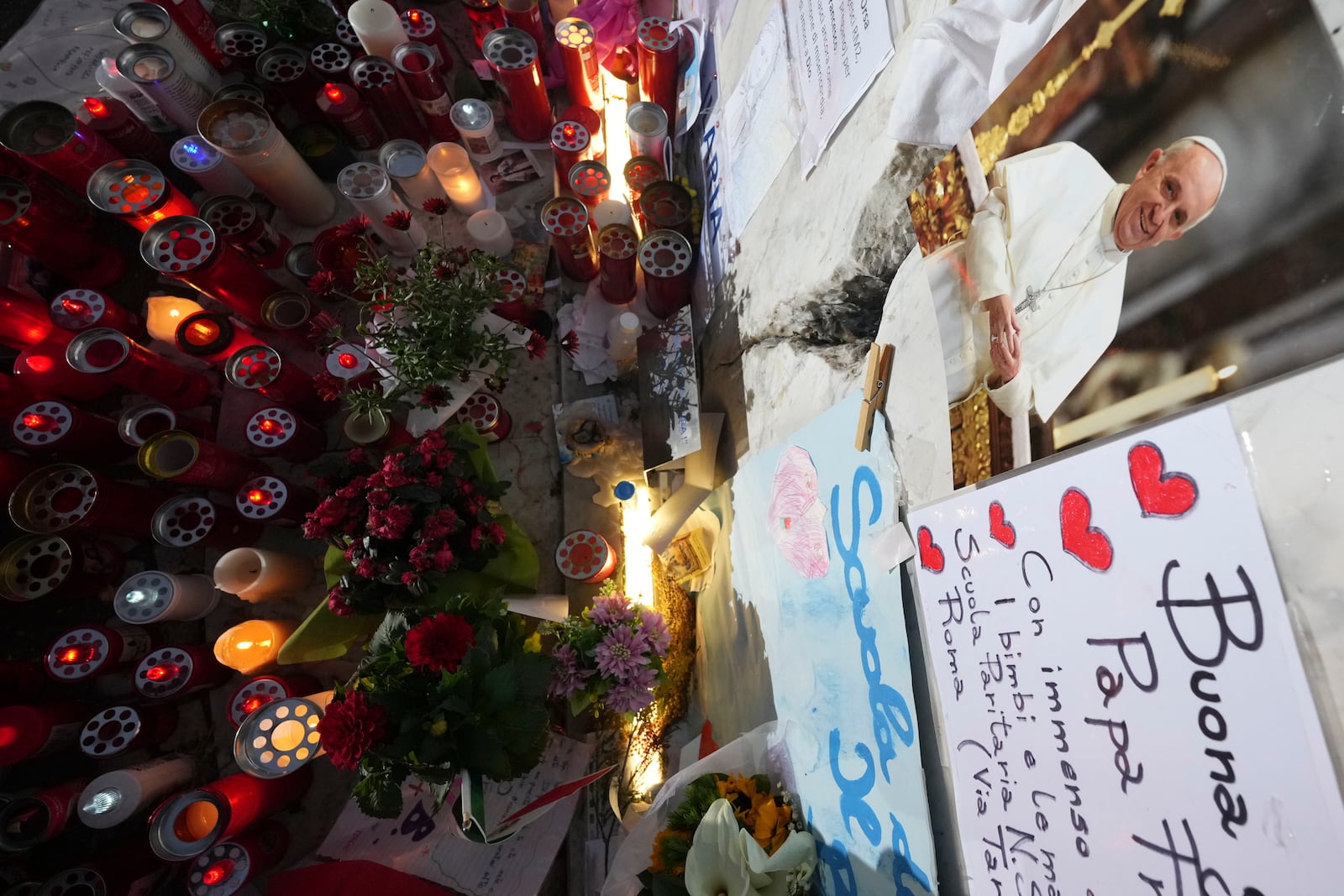 People pray for Pope Francis in front of the Agostino Gemelli Polyclinic, in Rome, Friday, March 7, 2025, where the Pontiff is hospitalized since Friday, Feb. 14. (AP Photo/Andrew Medichini)