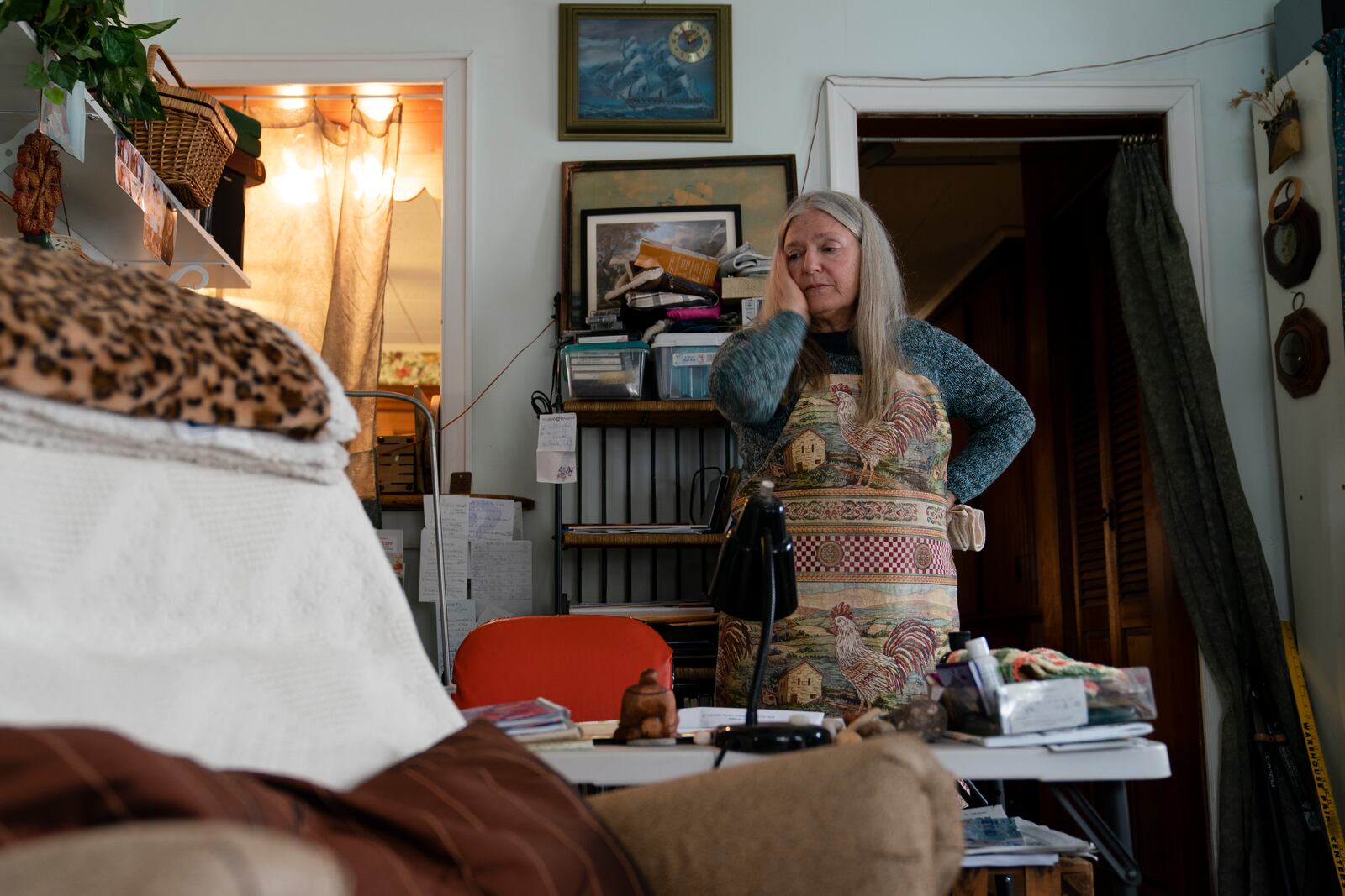 FILE - Nancy Rose, who contracted COVID-19 in 2021 and exhibits long-haul symptoms including brain fog and memory difficulties, pauses while organizing her desk space, Jan. 25, 2022, in Port Jefferson, N.Y. (AP Photo/John Minchillo, File)