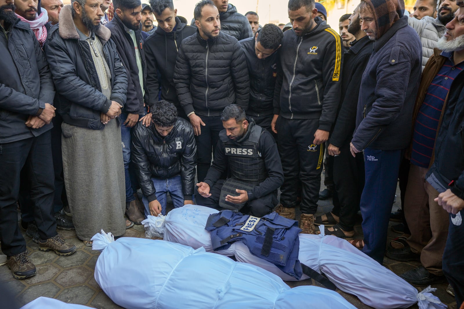 Colleagues and friends mourn over the body of freelance journalist Omar al-Derawi and other victims of overnight Israeli army strikes at multiple locations in central Gaza Strip, at Al-Aqsa Martyrs Hospital in Deir al-Balah, Friday, Jan. 3, 2025. According to Al-Aqsa Martyrs Hospital, 30 people, including 10 women and 7 children, were killed in several attacks overnight in central Gaza. (AP Photo/Abdel Kareem Hana)