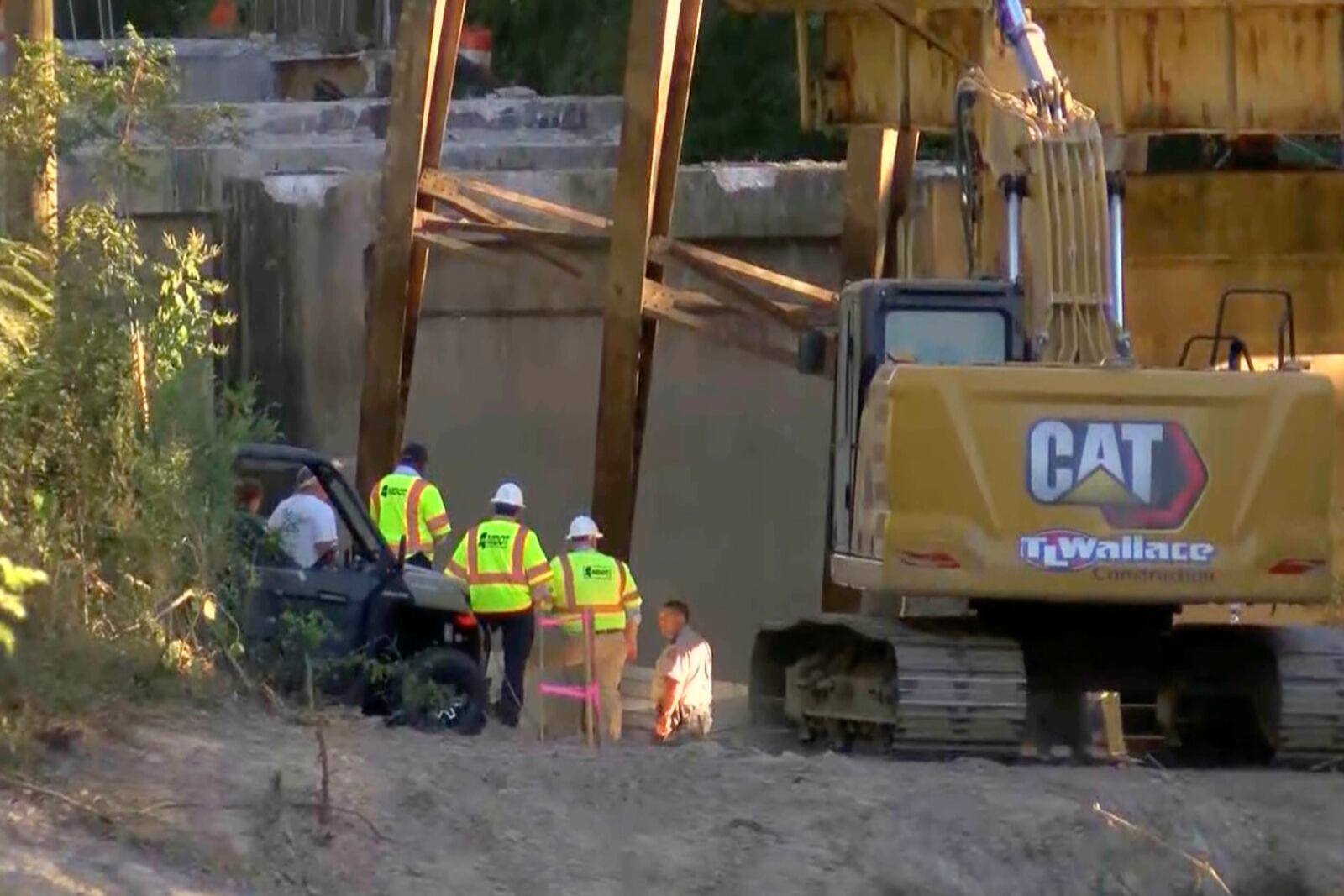 This image taken from video from WLBT shows law enforcement and Missouri Department of Transportation workers at the scene after a bridge over the Strong River on State Route 149 in Simpson County, Miss., collapsed on Wednesday, Oct. 16, 2024. (WLBT via AP)