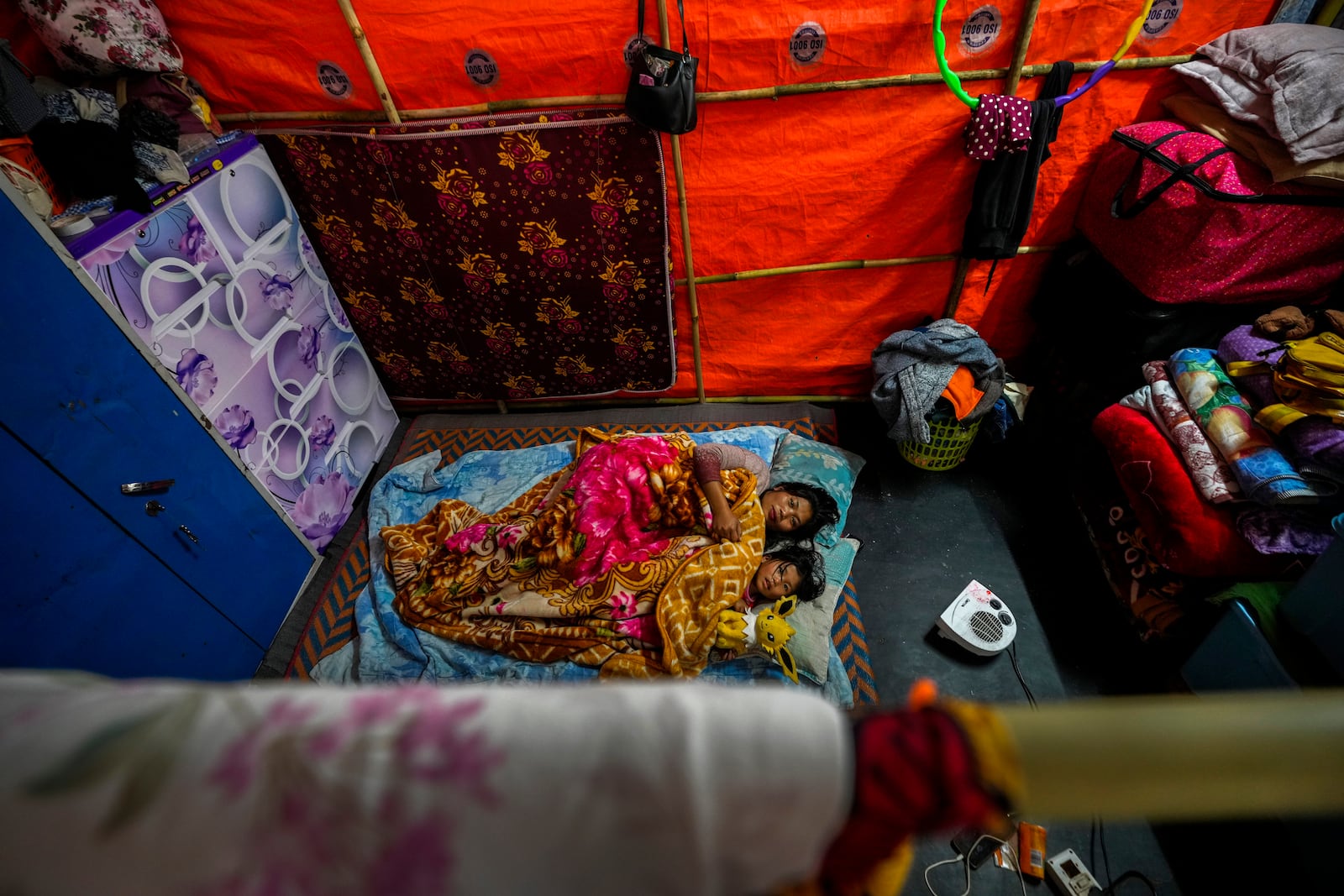 A Kuki tribal woman and her daughter rest in a relief camp in Kangpokpi, Manipur, Sunday, Dec. 15, 2024. (AP Photo/Anupam Nath)