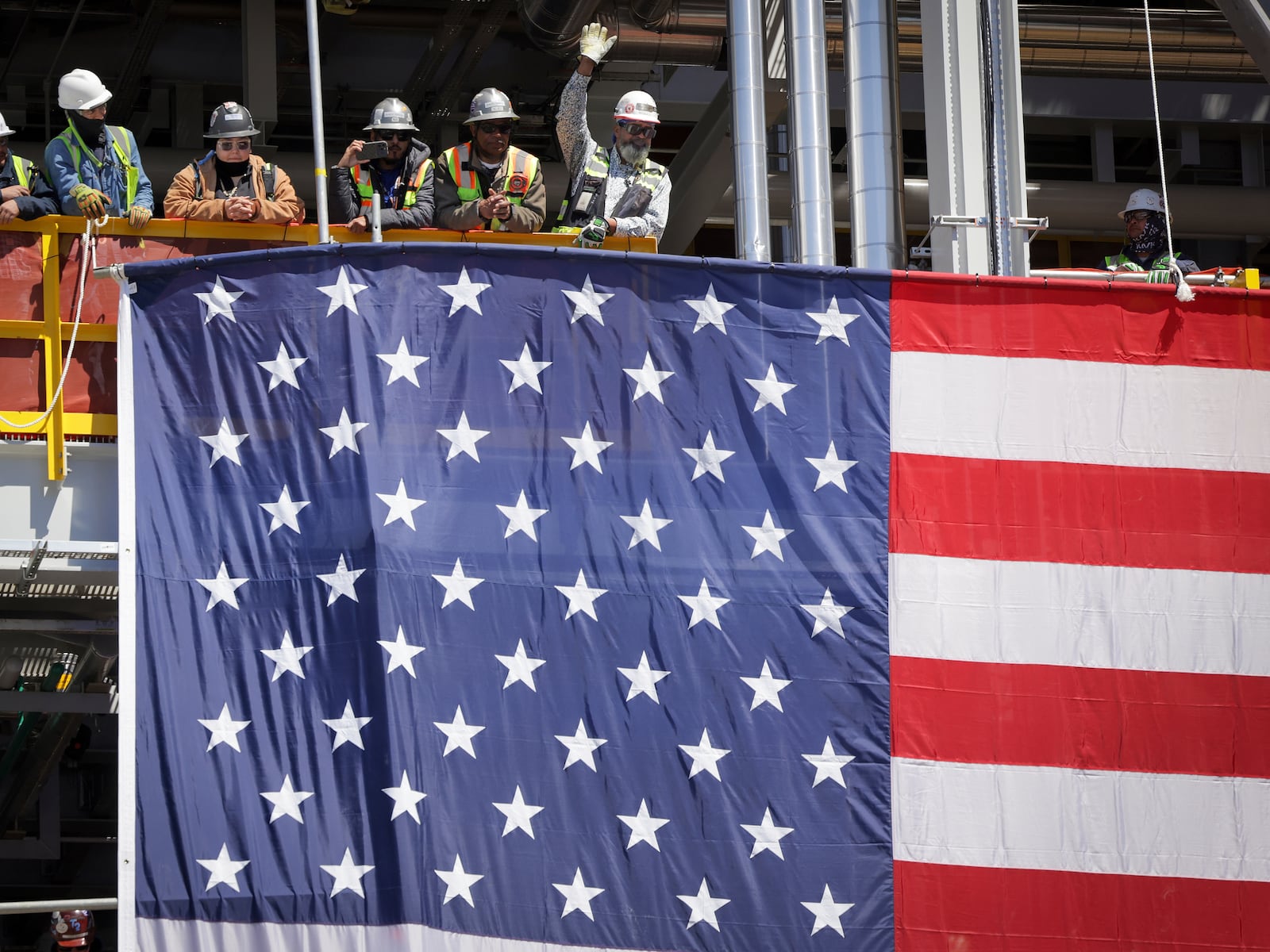 Workers gather as U.S. Secretary of Energy Chris Wright, Secretary of the Interior Doug Burgum and Louisiana Gov. Jeff Landry speak at Venture Global's Plaquemines LNG export facility Thursday, March 6, 2025, in Plaquemines, La. (Brett Duke/The Advocate via AP)