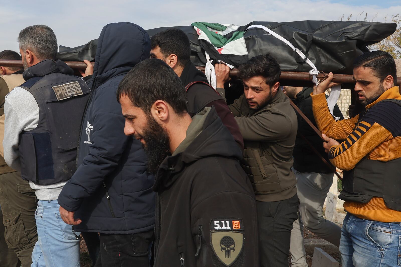 Colleagues and friends carry the body of Syrian photographer Anas Alkharboutli, 32, for his burial in Idlib, Syria, Wednesday Dec. 4, 2024. Alkharboutli, working for the German news agency DPA was killed in an airstrike near the city of Hama, the agency said Wednesday.(AP Photo/Ghaith Alsayed)