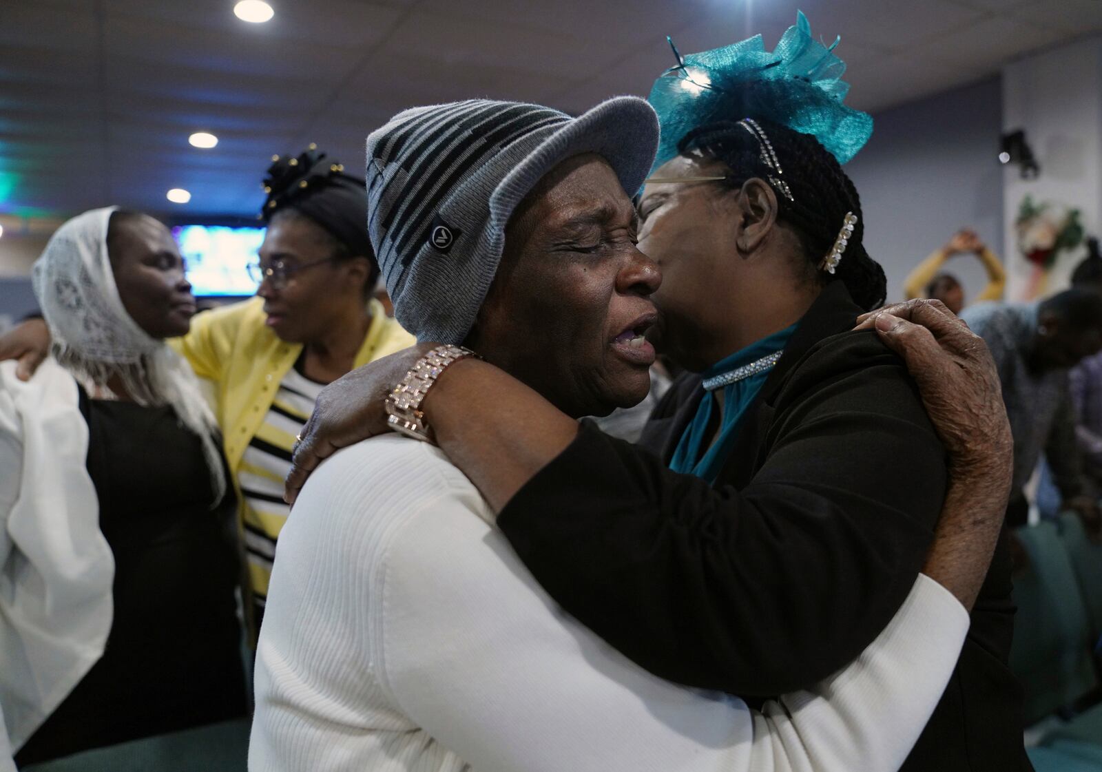 Marie Guillou, front left, hugs and worships with a fellow congregant at the First Haitian Evangelical Church of Springfield, Sunday, January 26, 2025, in Springfield, Ohio. (AP Photo/Jessie Wardarski)