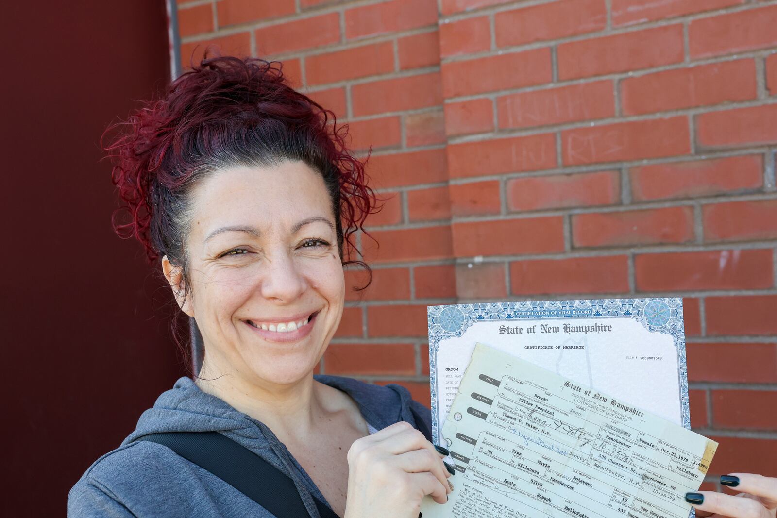 Brooke Younge holds her marriage certificate and birth certificate after registering to vote for the first time in Derry, N.H., Tuesday, March 11, 2025. (AP Photo/Reba Saldanha)