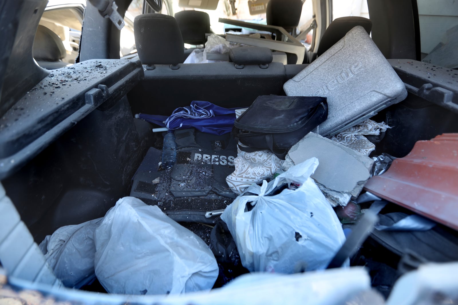 A flack jacket and other items left inside a destroyed car, at the site where an Israeli airstrike hit a compound housing journalists, killing three media staffers from two different news agencies according to Lebanon's state-run National News Agency, in Hasbaya village, southeast Lebanon, Friday, Oct. 25, 2024. (AP Photo/Mohammed Zaatari)