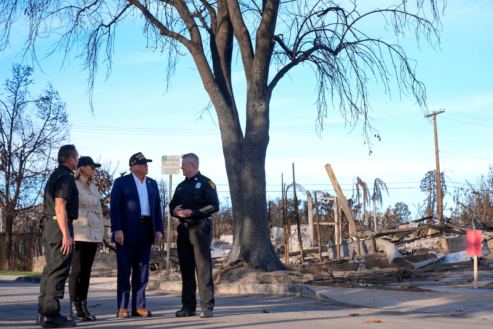 President Donald Trump and first lady Melania Trump walk with Jason Hing, chief deputy of emergency services at the Los Angles Fire Department, left, and Capt. Jeff Brown, chief of Station 69, as they tour the Pacific Palisades neighborhood affected by recent wildfires in Los Angeles, Friday, Jan. 24, 2025. (AP Photo/Mark Schiefelbein)