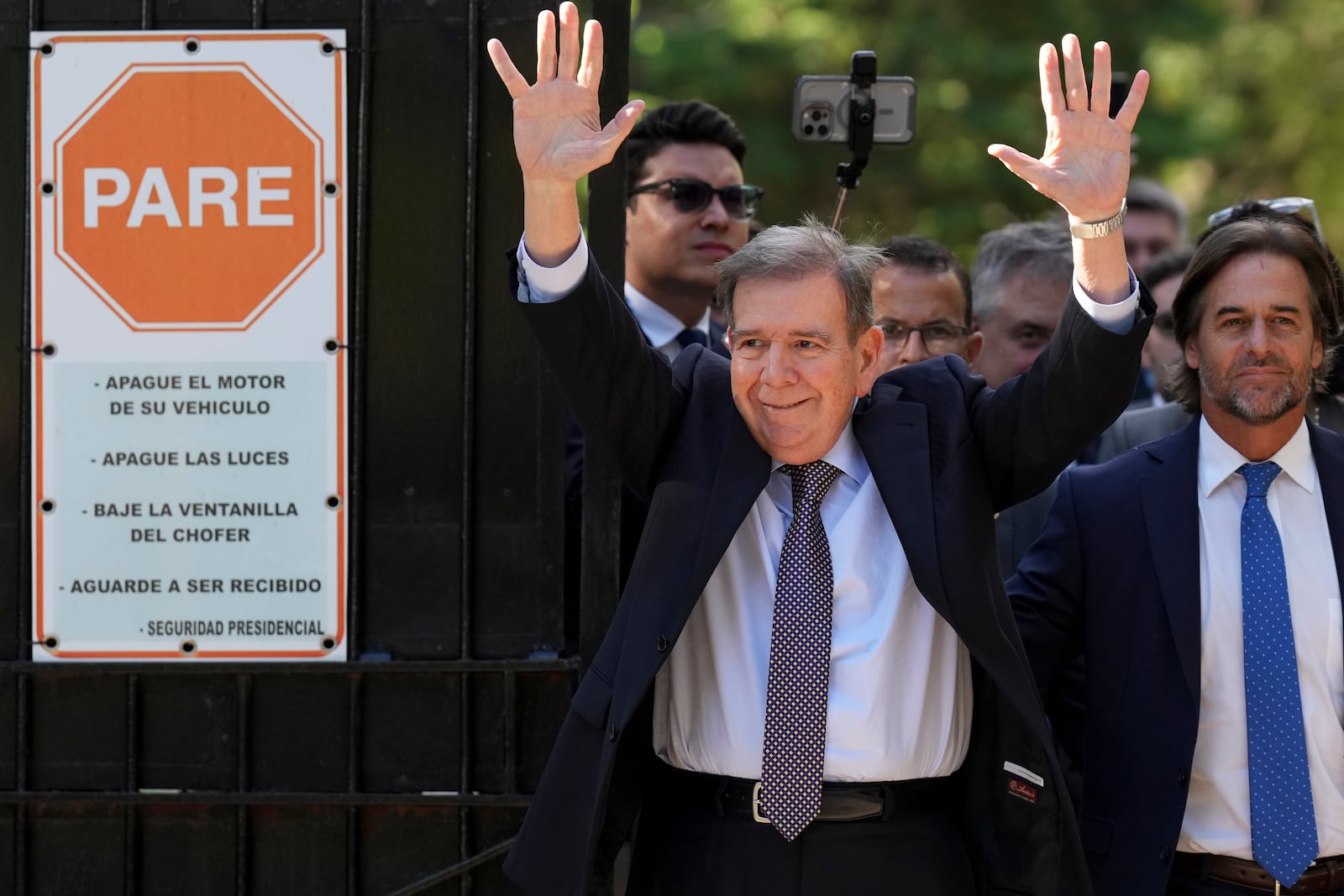 Venezuela's opposition leader Edmundo Gonzalez Urrutia, left, waves to supporters beside Uruguayan President Luis Lacalle Pou outside the government residence in Montevideo, Uruguay, Saturday, Jan. 4, 2025. Gonzalez, who claims he won the 2024 presidential election and is recognized by some countries as the legitimate president-elect, traveled from exile in Madrid to Argentina and Uruguay. (AP Photo/Matilde Campodonico)