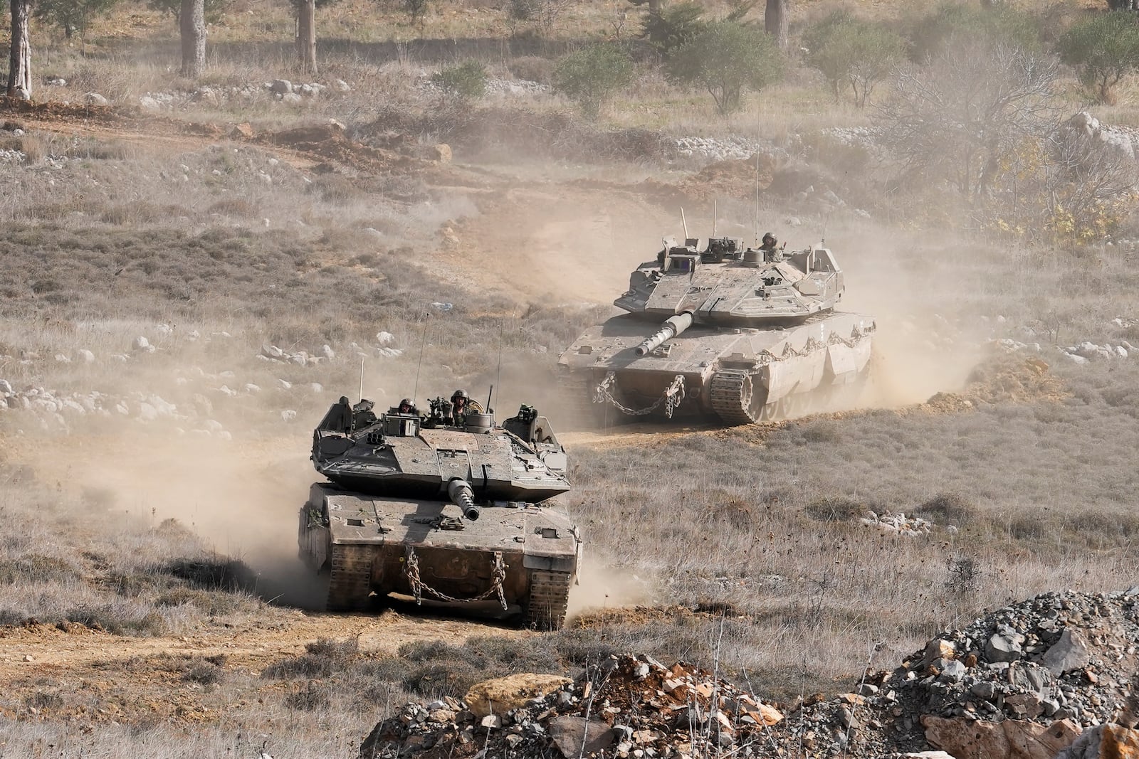 Israeli tanks maneuver next to the security fence near the so-called Alpha Line that separates the Israeli-annexed Golan Heights from Syria, in the town of Majdal Shams, Wednesday, Dec. 11, 2024. (AP Photo/Matias Delacroix)