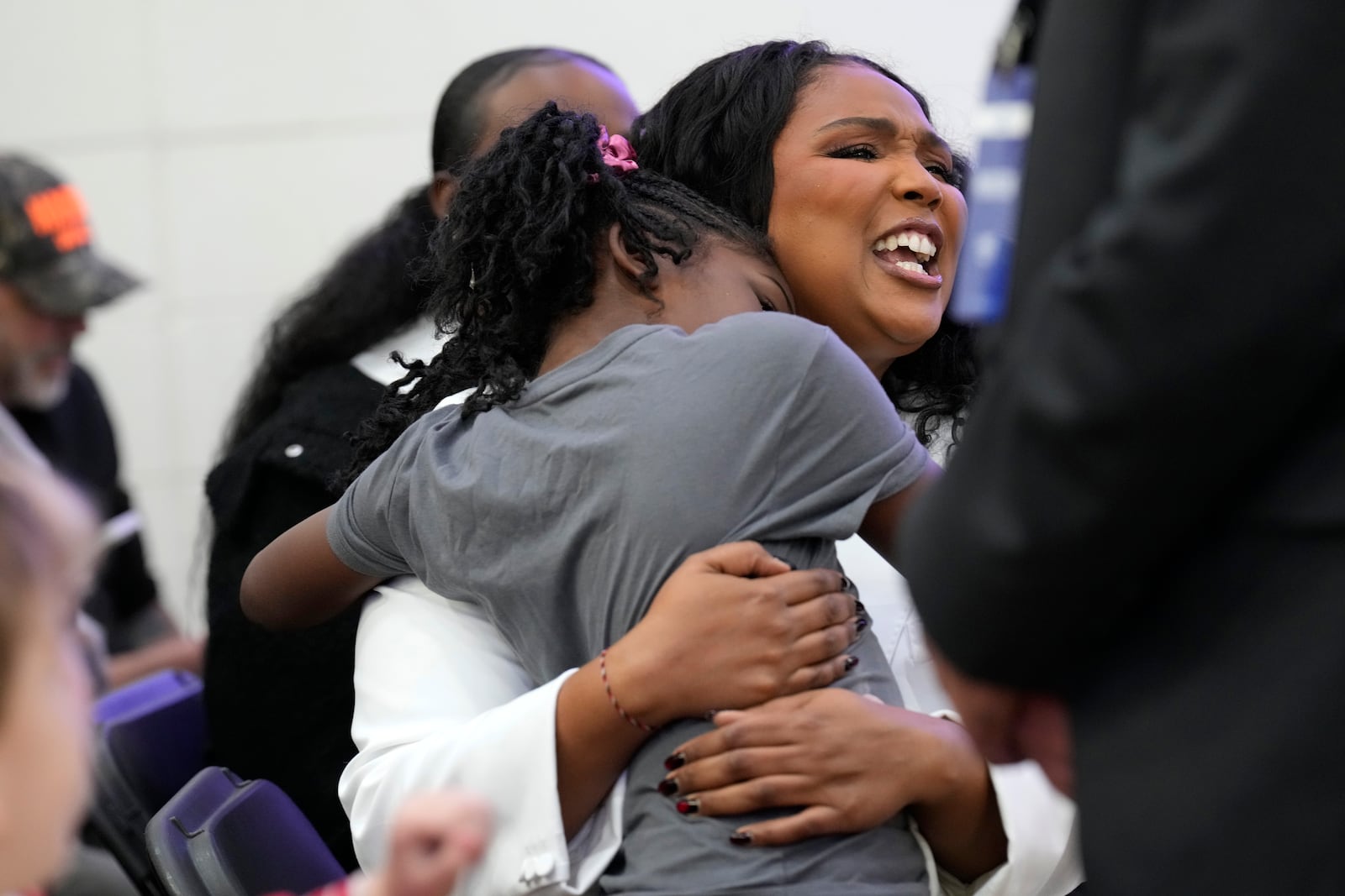 Lizzo, right, sits with a young attendee before Democratic presidential nominee Vice President Kamala Harris speaks during a campaign event at Western International High School in Detroit, Saturday, Oct. 19, 2024. (AP Photo/Jacquelyn Martin)