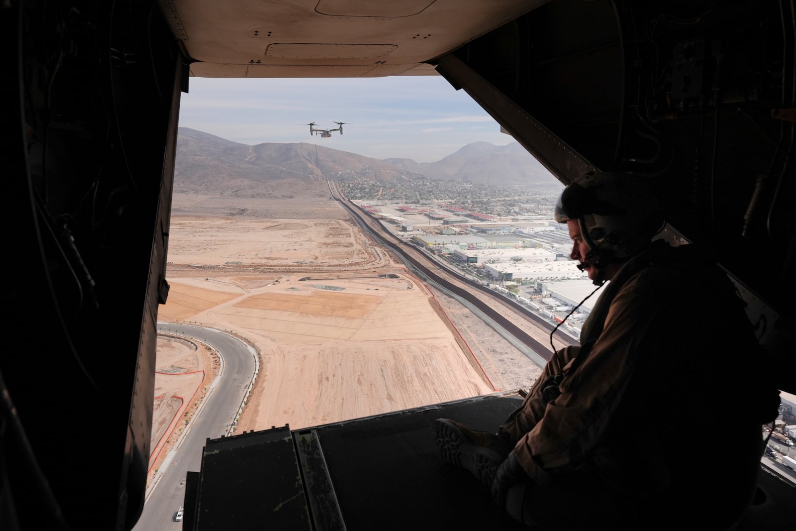 Military personnel flies along the U.S. Mexico border Friday, Jan. 31, 2025, near San Diego. (AP Photo/Jae C. Hong)