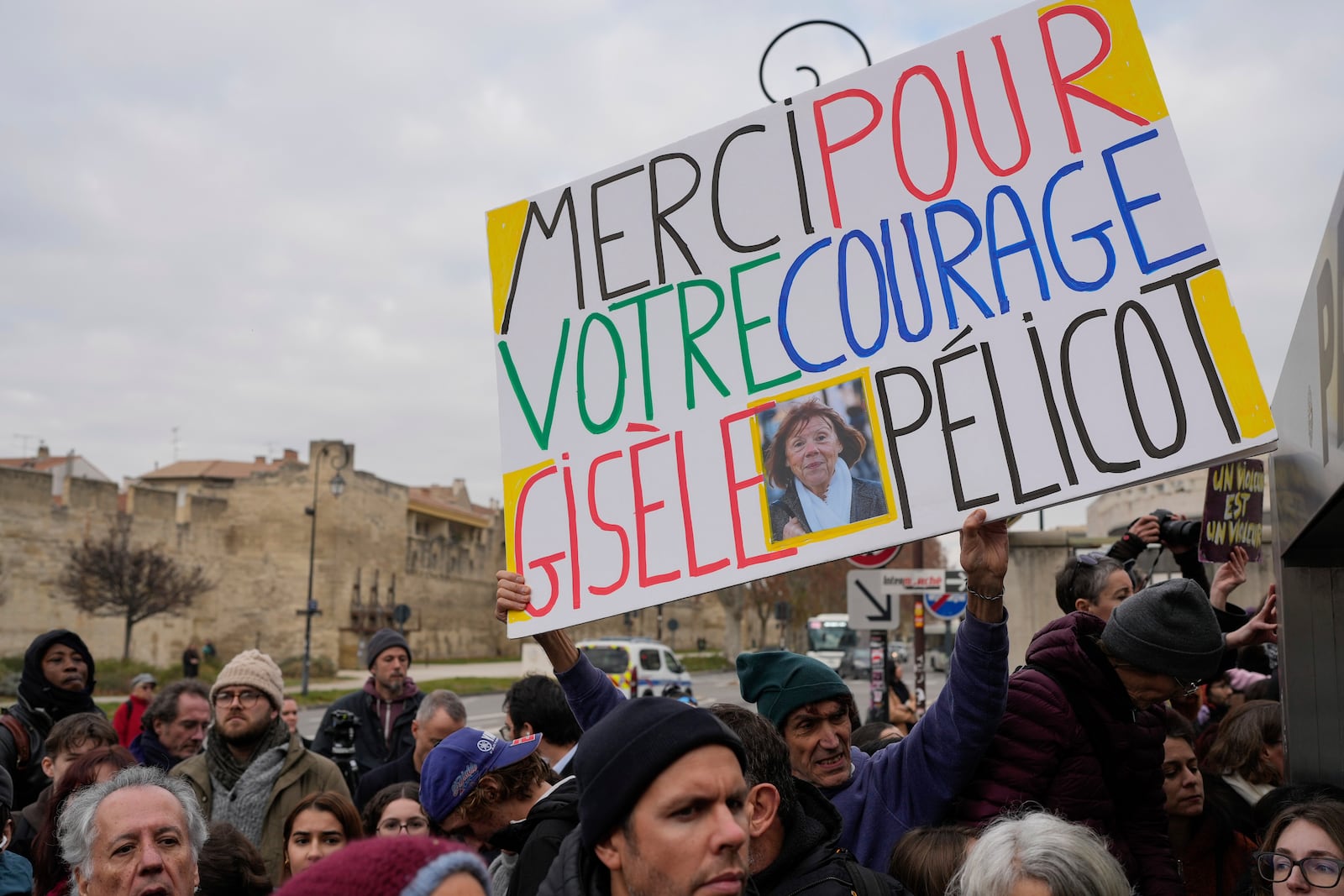 A man holds a placard reading "Thank you for your courage Gisele Pelicot" outside the Avignon courthouse, southern France, Thursday, Dec. 19, 2024. (AP Photo/Lewis Joly)