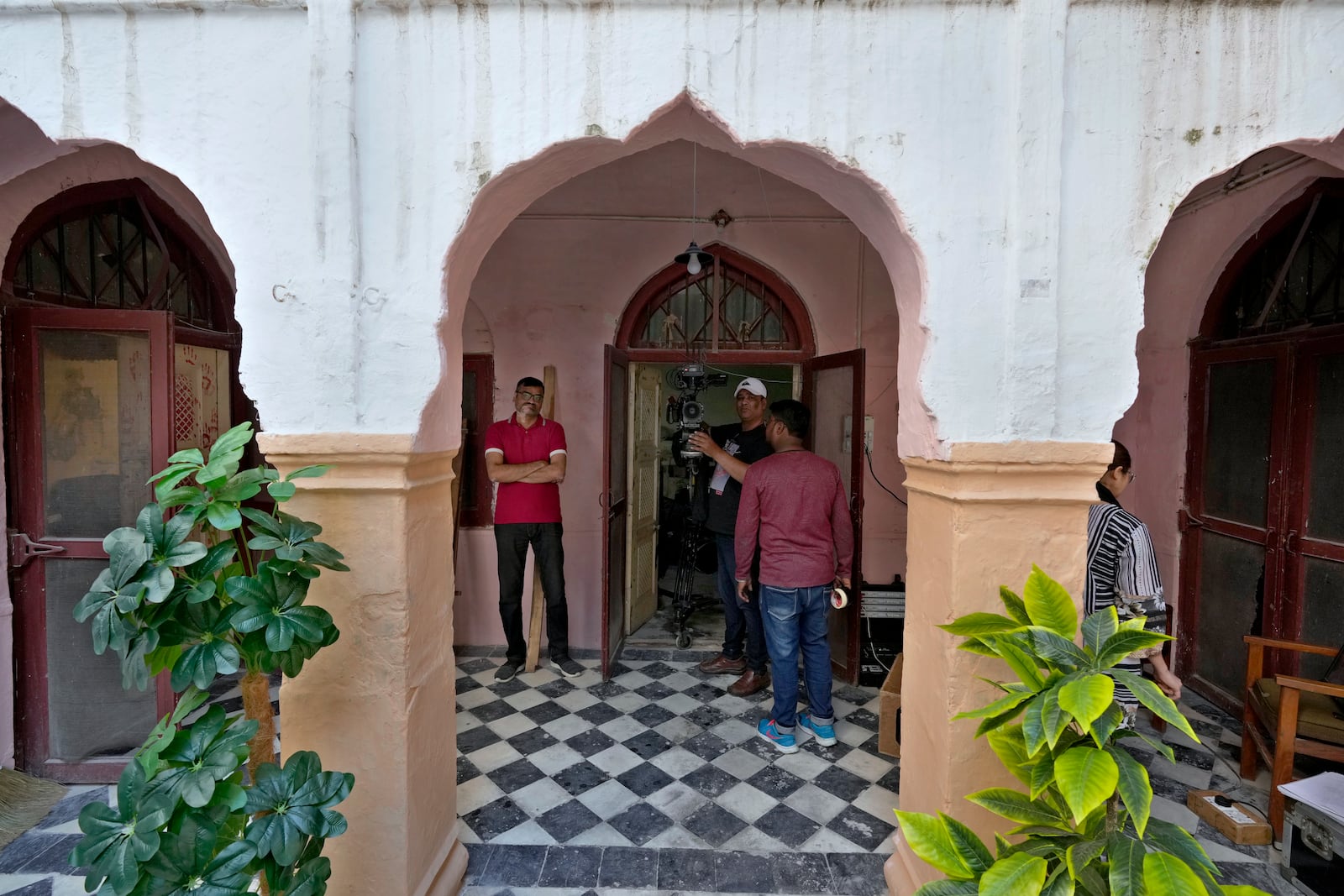 A cameraman and technicians prepare themselves for next shot during the shooting of a scene of tv drama serial ''Tan Man Neel-o-Neel' or Deeply Engrossed in Love',, in Rawalpindi, Pakistan, Saturday, Nov. 2, 2024. (AP Photo/Anjum Naveed)