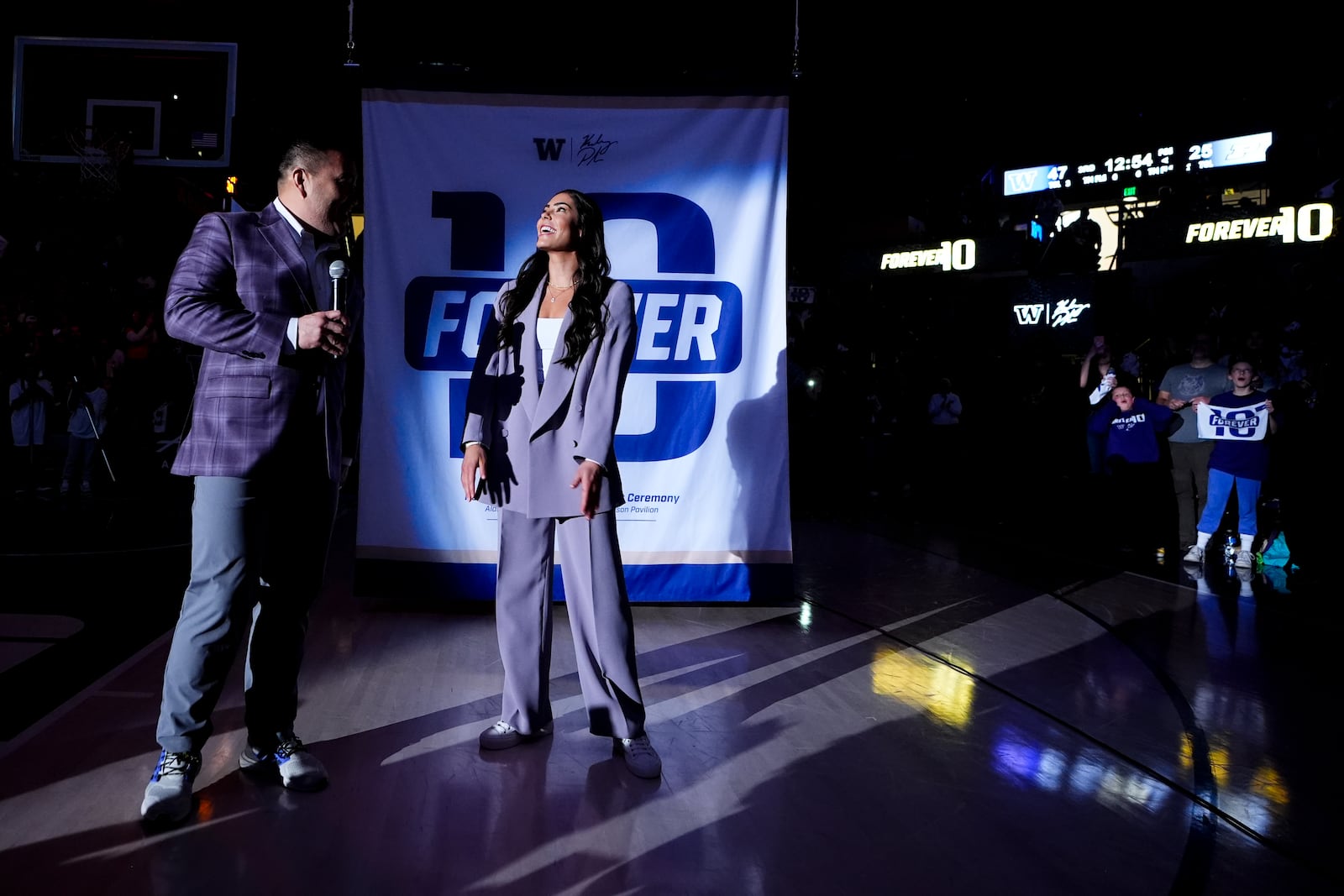 Former Washington guard and current Las Vegas Aces player Kelsey Plum, right, reacts with Washington athletic director Pat Chun, left, during her jersey retirement ceremony during halftime of an NCAA college basketball game between Washington and Purdue Saturday, Jan. 18, 2025, in Seattle. (AP Photo/Lindsey Wasson)