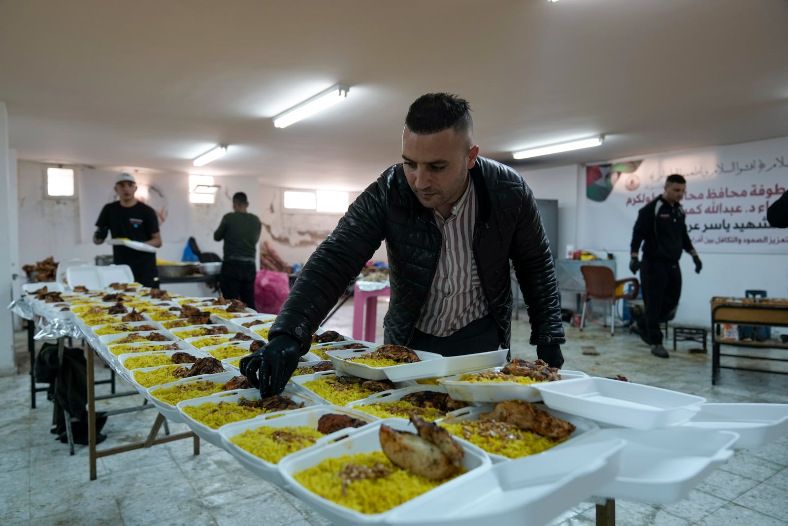 Volunteers at the Yasser Arafat Charity Kitchen in Tulkarem, West Bank, prepare an iftar meal for displaced Palestinians trying to mark the Muslim holy month of Ramadan on Monday, March 3, 2025. (AP Photo/Majdi Mohammed)