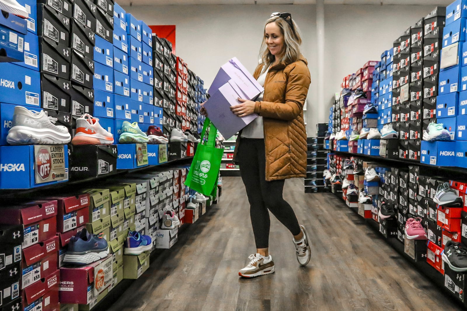 FILE - Ashley Crafton looks at tennis shoes at at Shoe Stop while shopping during Small Business Saturday in Wesleyan Park Plaza on Nov. 25, 2023, in Owensboro, Ky. (Greg Eans/The Messenger-Inquirer via AP, File)