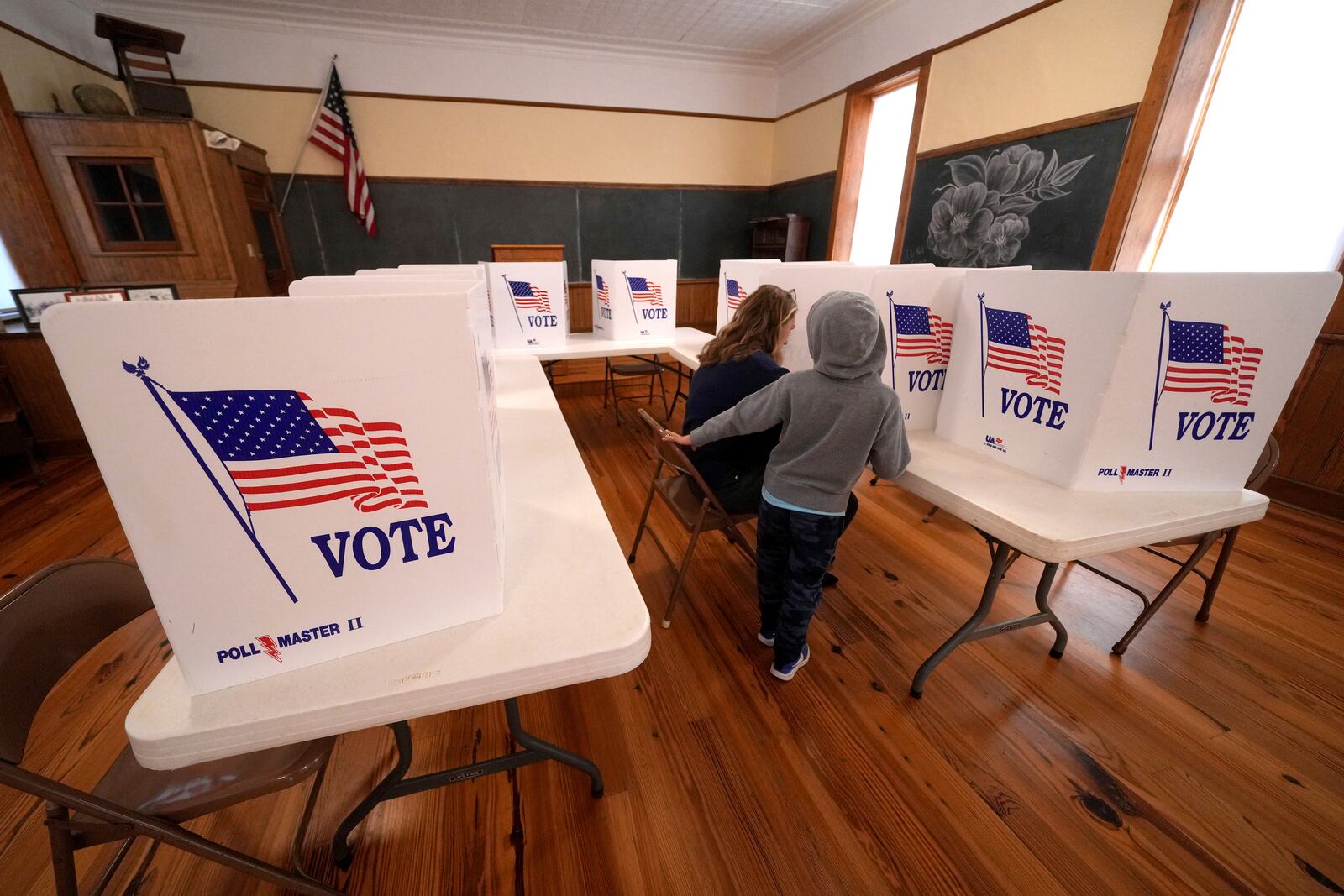 FILE - Aliza Bidinger is accompanied by her son Jayce, as she votes at the 146-year-old Buck Creek school on Election Day, Nov. 5, 2024, in rural Perry, Kan. (AP Photo/Charlie Riedel, File)