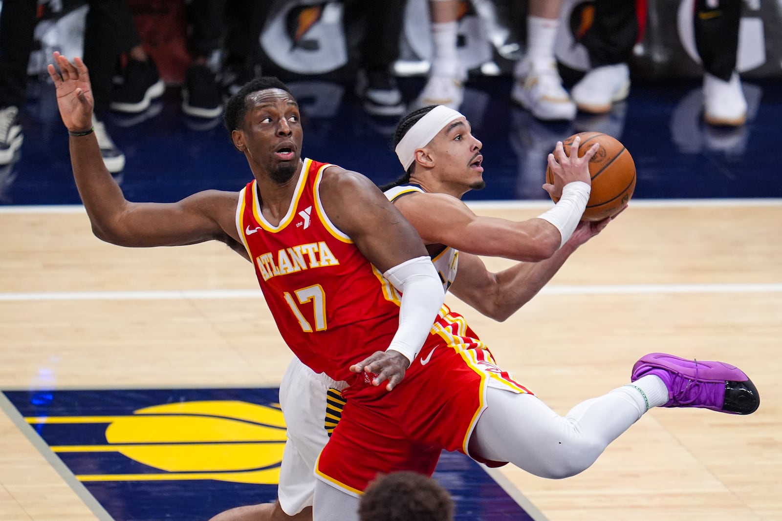 Indiana Pacers guard Andrew Nembhard (2) is fouled as he shoots behind Atlanta Hawks forward Onyeka Okongwu (17) during the second half of an NBA basketball game in Indianapolis, Saturday, Feb. 1, 2025. (AP Photo/Michael Conroy)